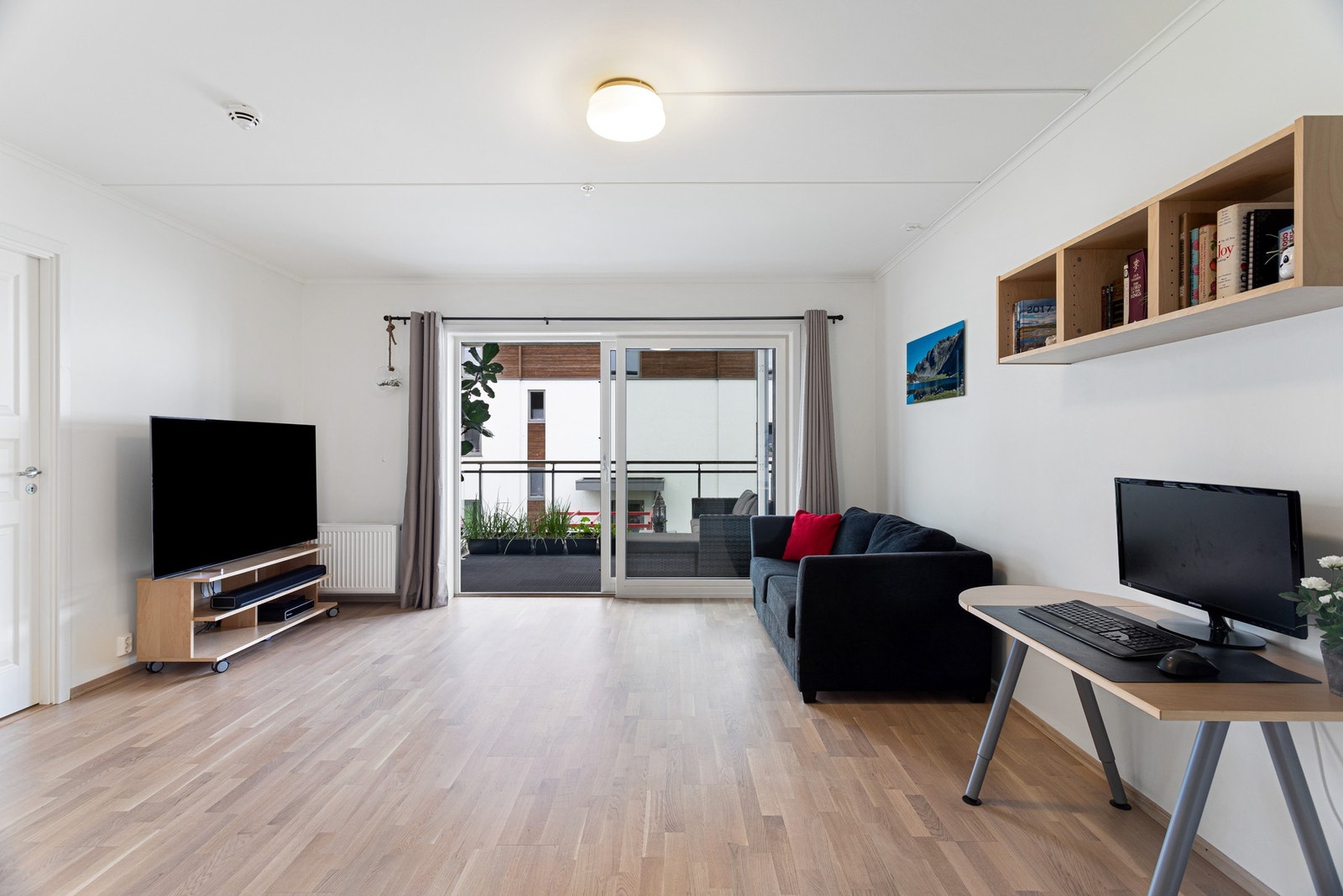 Lys og trivelig stue med skyvedører ut til balkongen Galleribilde