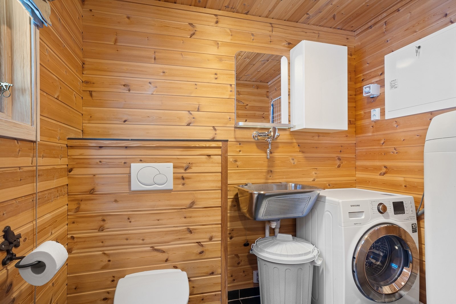 Praktisk vaskerom med flislagt gulv og ekstra toalett Galleribilde