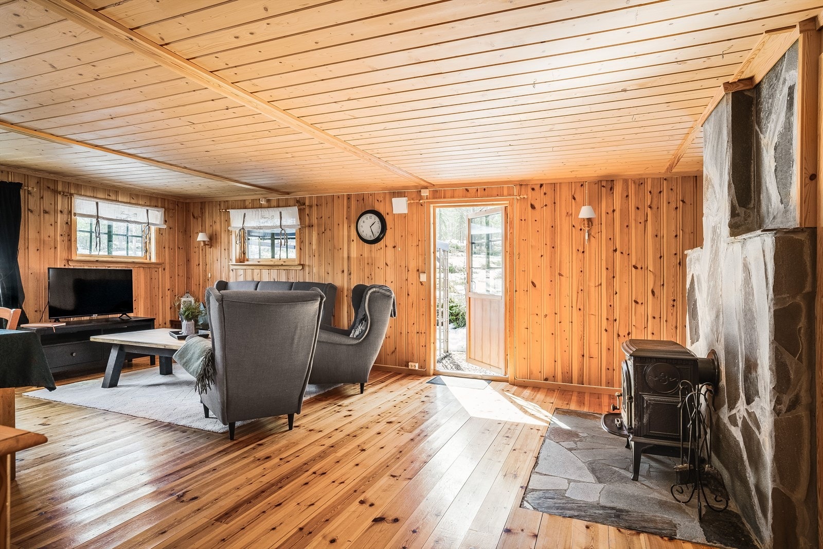 I stuen er det installert peis som bidrar til ekstra varme og koselig atmosfære når det knitrer i tørr bjørkeved. Rommet har utgang til en koselig uteplass med både bålpanneområde og pergola. Galleribilde