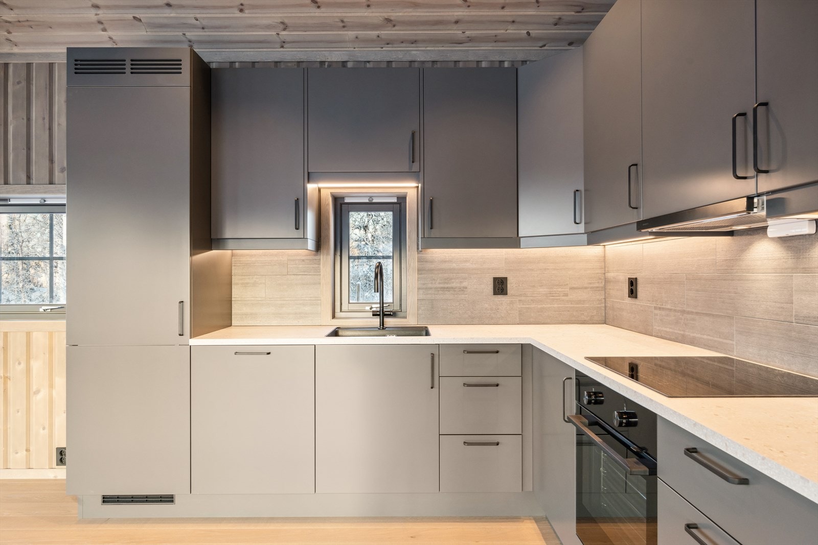 Kjøkkeninnredningen har glatte fronter og benkeplate av laminat. Det er godt med skap og benkeplass, og lekre fliser mellom over- og underskap. Galleribilde