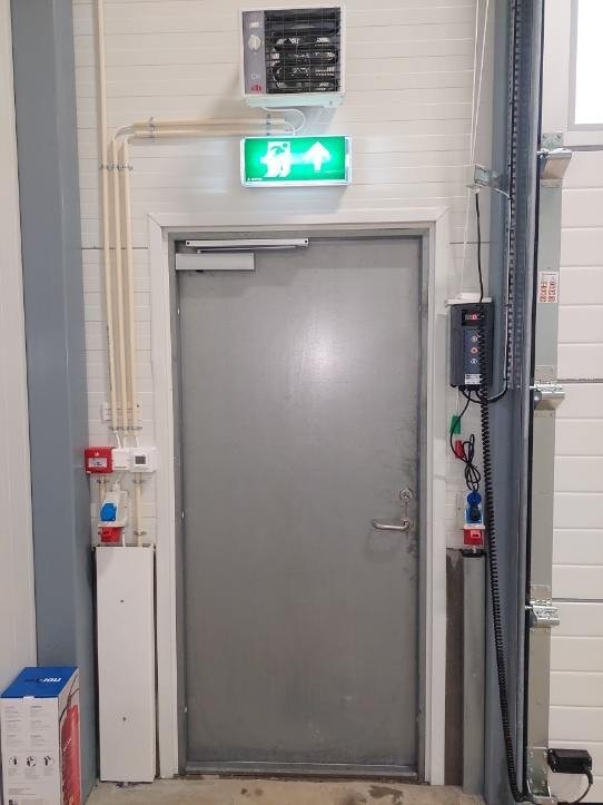 Inngangsdør til lager med varmevifte og strømuttak. Galleribilde