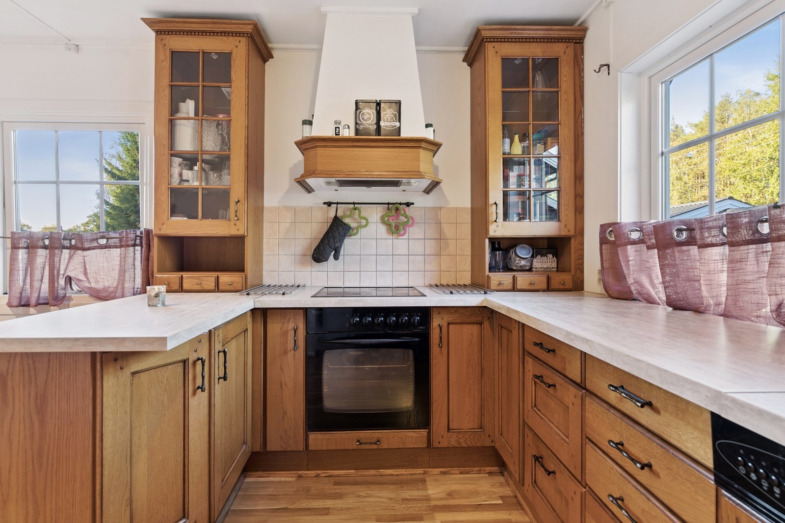 Kjøkkenet har en praktisk U-form med profilerte fronter i tre og rikelig med skap- og benkeplass. Galleribilde