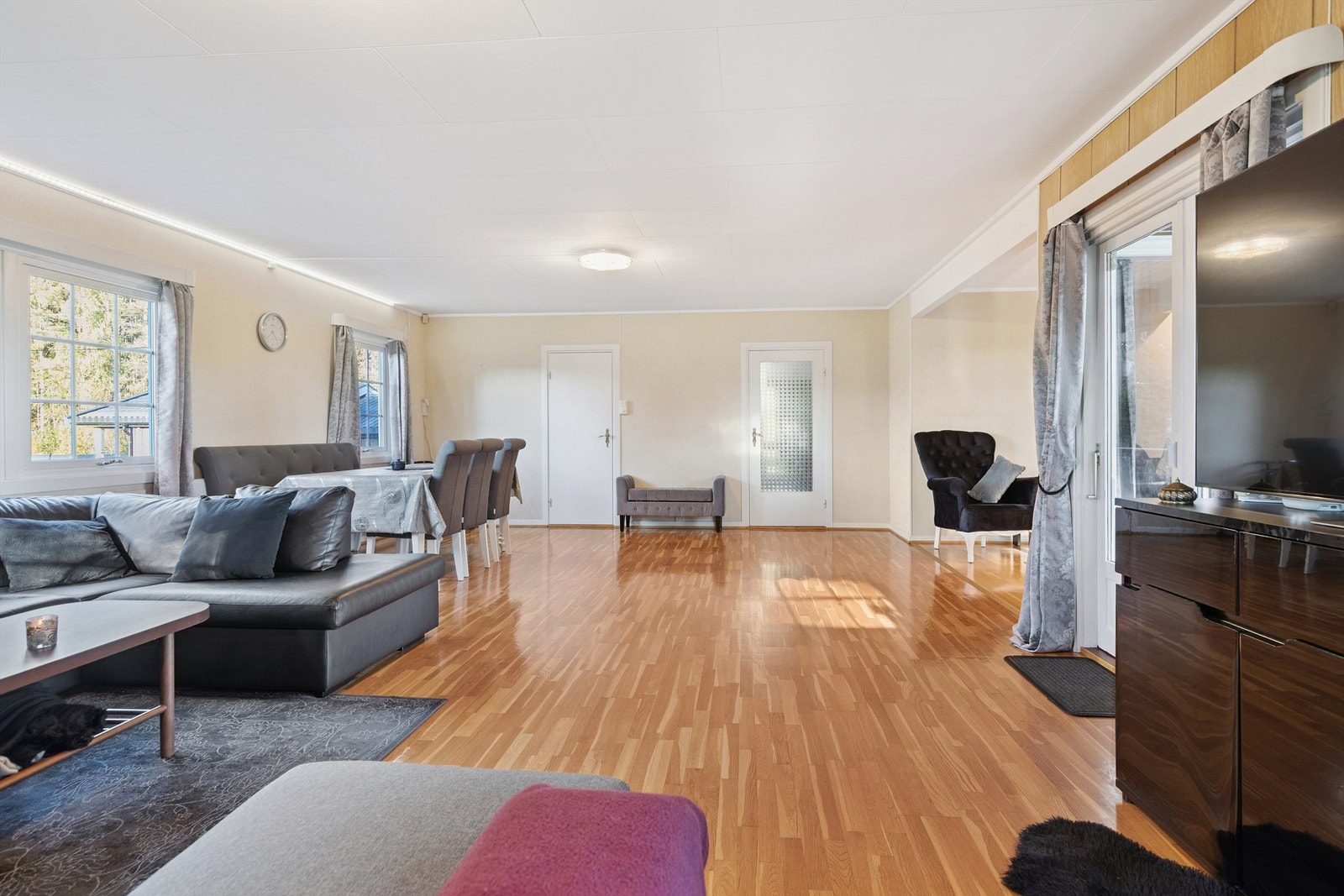 Store vindusflater gir godt med naturlig lys, og rommet har en delvis åpen løsning mot kjøkkenet. Galleribilde