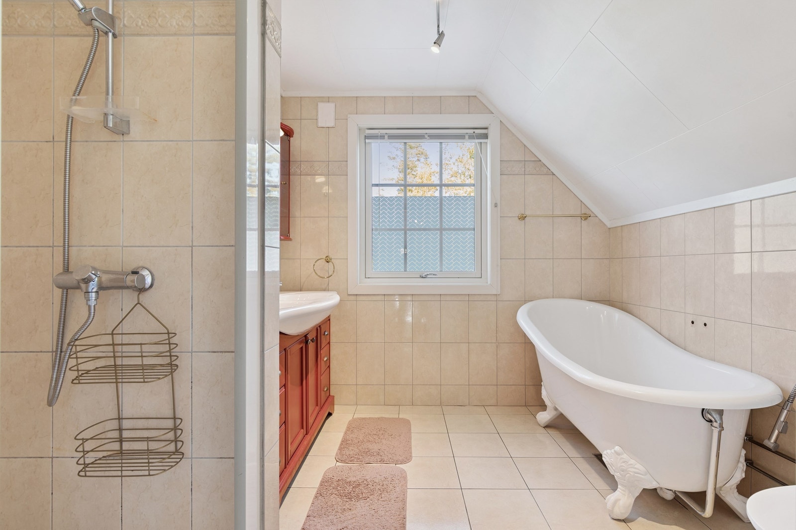 Badet i andre etasje er helfliset og utstyrt med både dusjnisje og et frittstående badekar. Galleribilde