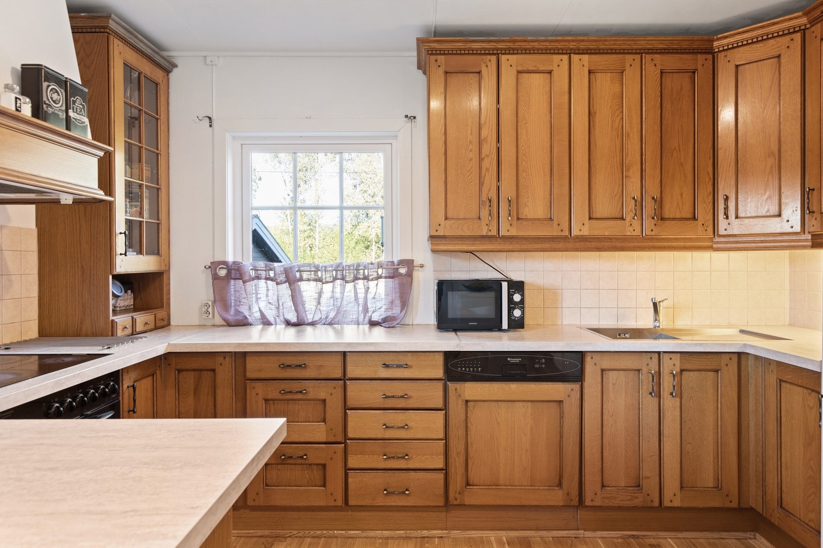 Innredningen inkluderer integrerte hvitevarer som platetopp, komfyr og oppvaskmaskin. Galleribilde