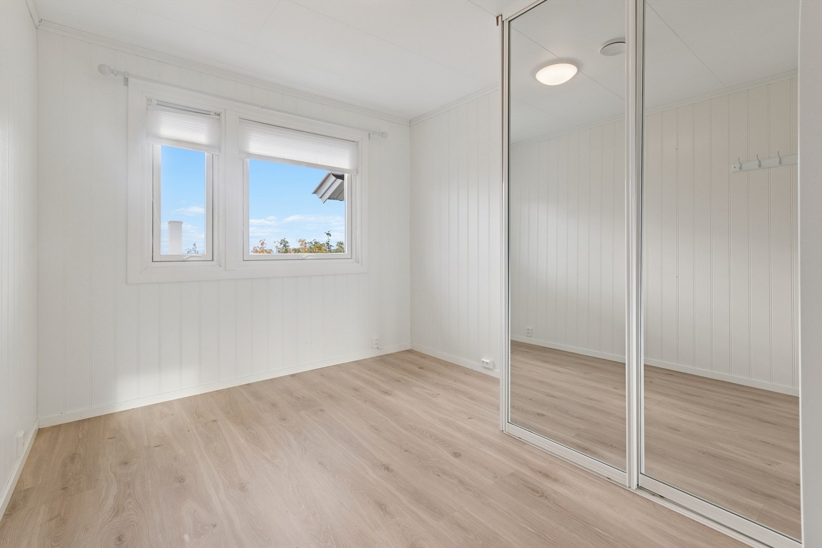 Soverom med stor skyvedørsgarderobe med speil i hjørne. Vakker utsikt til Børvasstindene. Ingen innsyn. Galleribilde