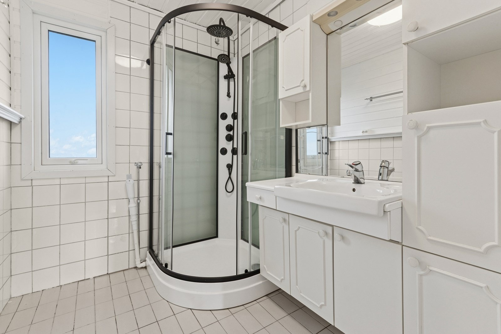 Badet i hovedetasjen er lyst og pent. Dusjkabinett fra 2024. Plass til vaskemaskin og tørketrommel. Galleribilde