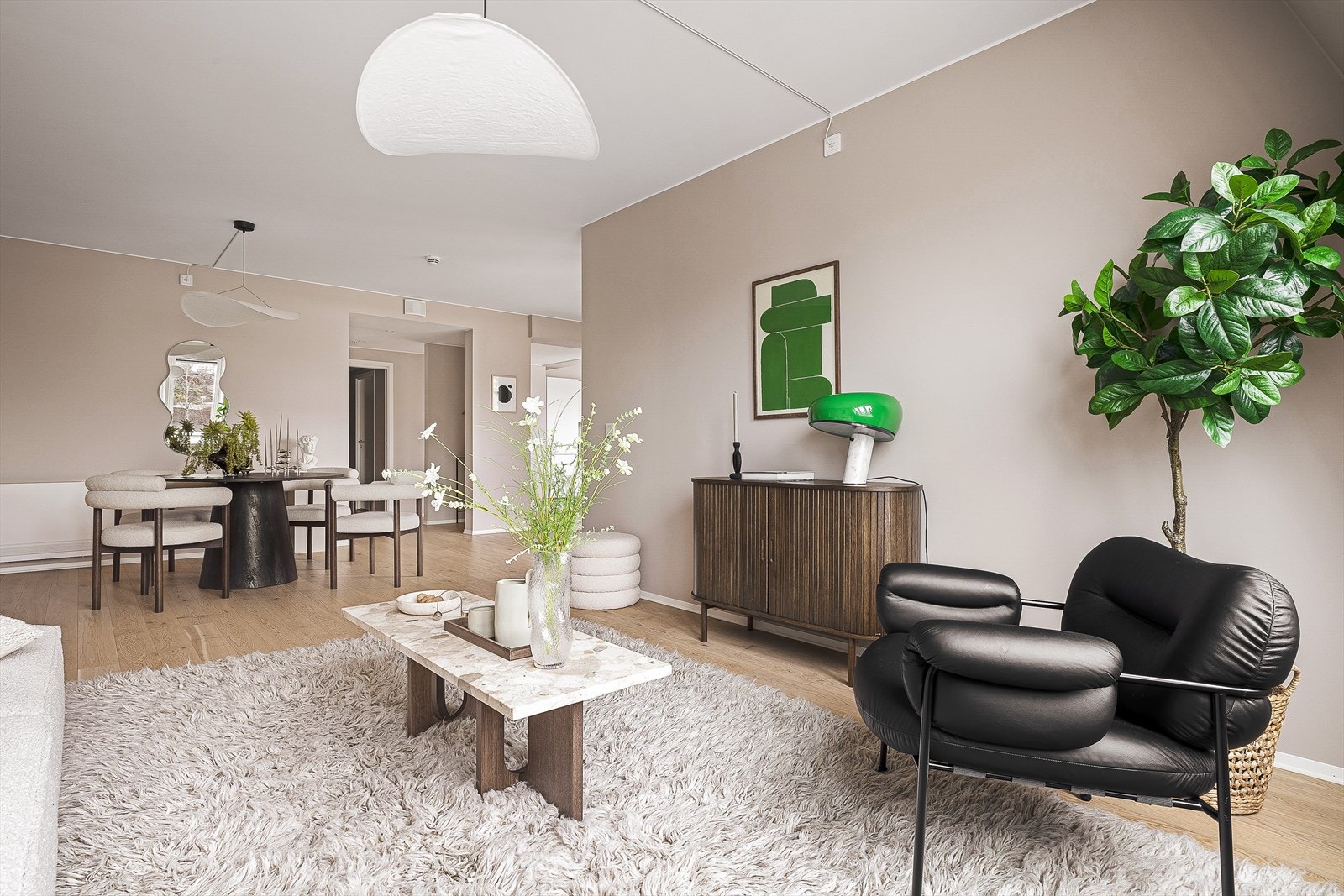 Leiligheten har en åpen stue- og kjøkkenløsning | Kjøkken, spiseplass og stue flyter sømløst sammen og skaper en harmonisk helhet med naturlige soner. Galleribilde