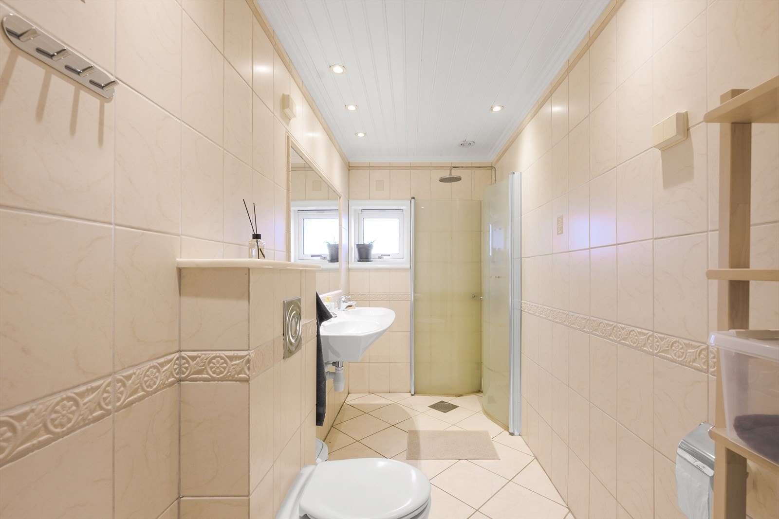 Flislagt baderom med elektriske varmekabler i gulvet og panel i himlingen. Et funksjonelt og moderne bad som gir en god start på dagen. Galleribilde