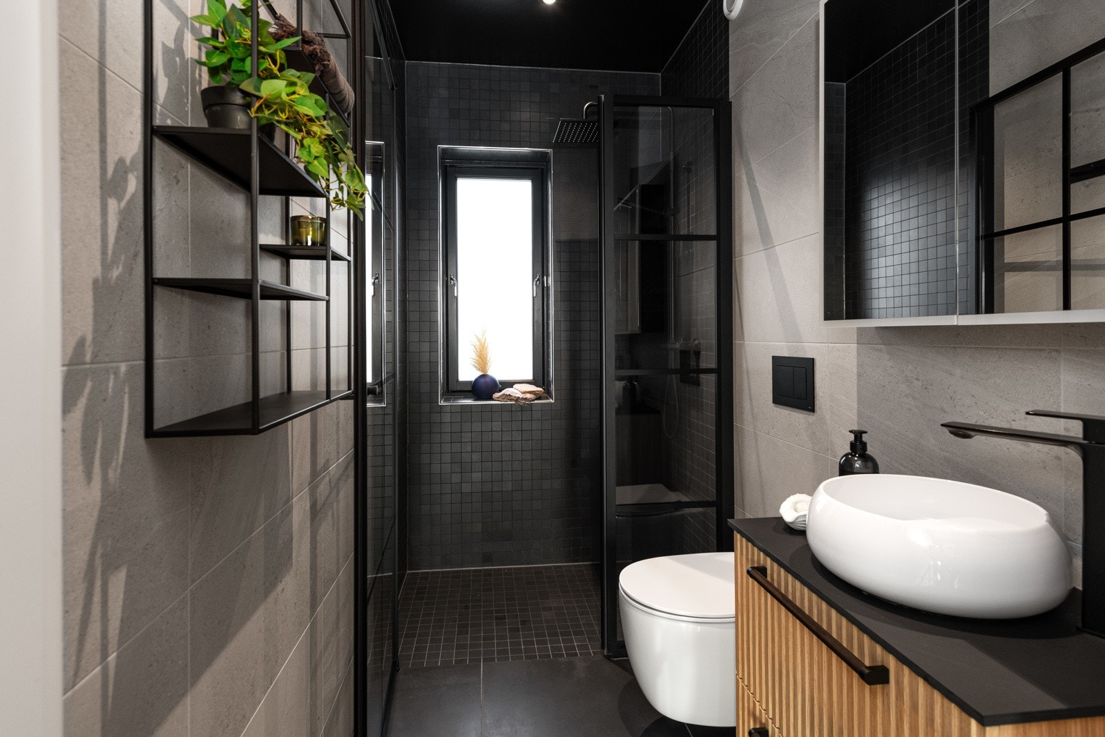 Bad i 3. etasje er innredet med servant med dobbel skuffeseksjon, speilskap, vegghengt wc. Dusjvegg og armatur i sort utførelse. Galleribilde