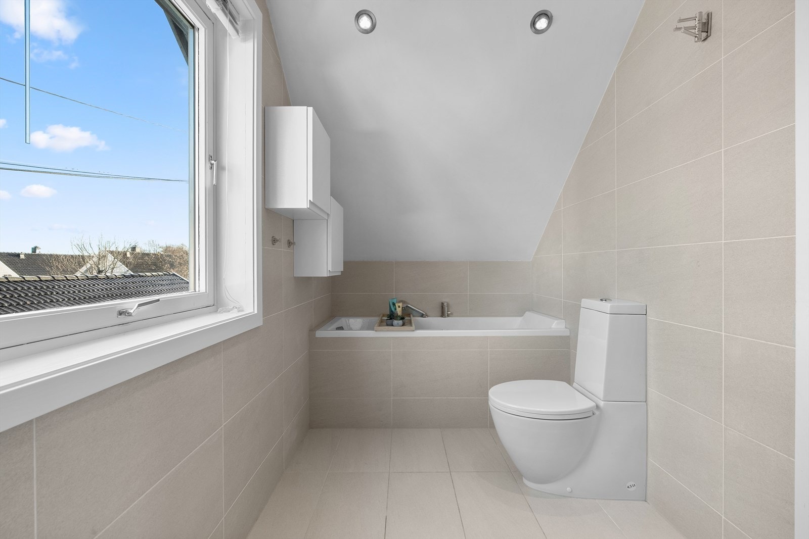 Rommet er praktisk innredet med toalett, servant nedfelt i innredning, dusjhjørne med svingbare glassdører og et komfortabelt badekar - perfekt for både raske morgendusjer og avslappende kveldsbad. Galleribilde