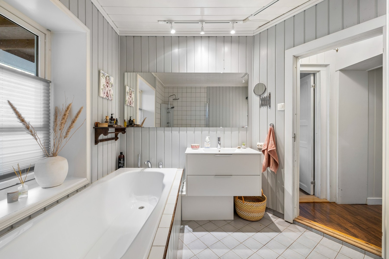 Badet er innredet med lysegrå gulvfliser og matchende panelvegger Galleribilde