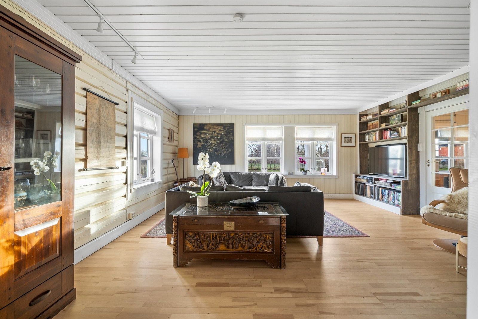 Veggen mot entreen har en stor og plassbygd hylleløsning, perfekt for bøker, planter og annen dekor Galleribilde