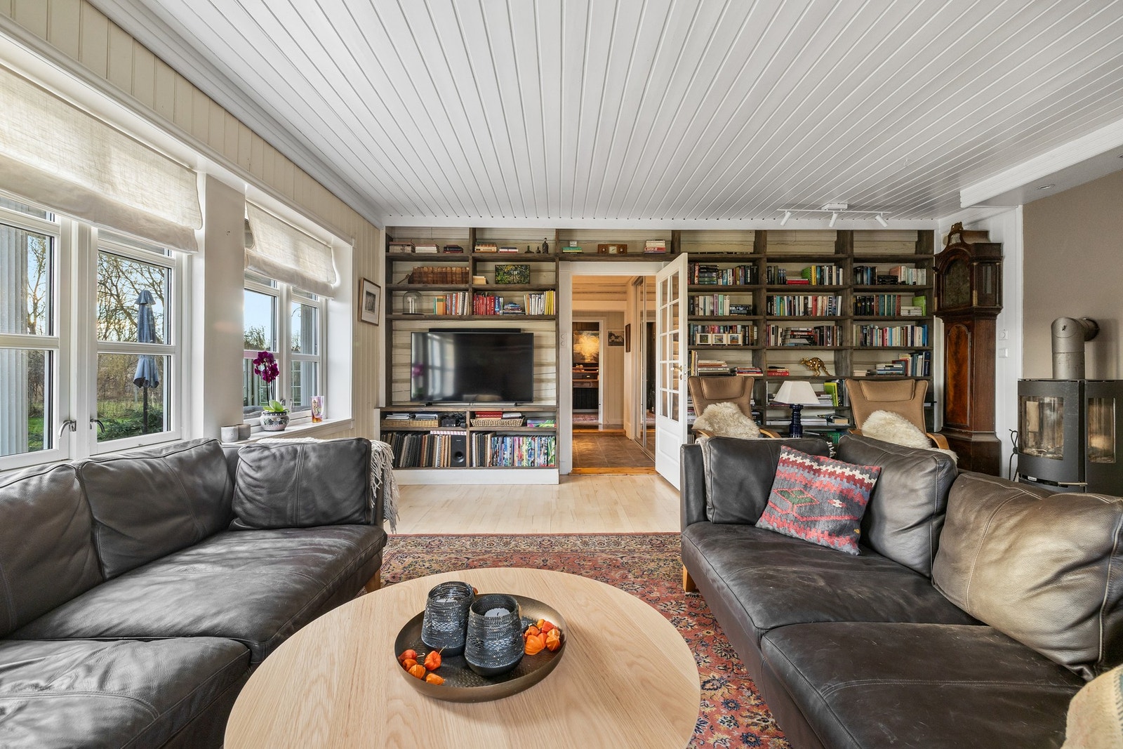 Stuen er åpen, romslig og innbydende, der sprossevinduer på to sider slipper inn godt med naturlig lys til rommet Galleribilde