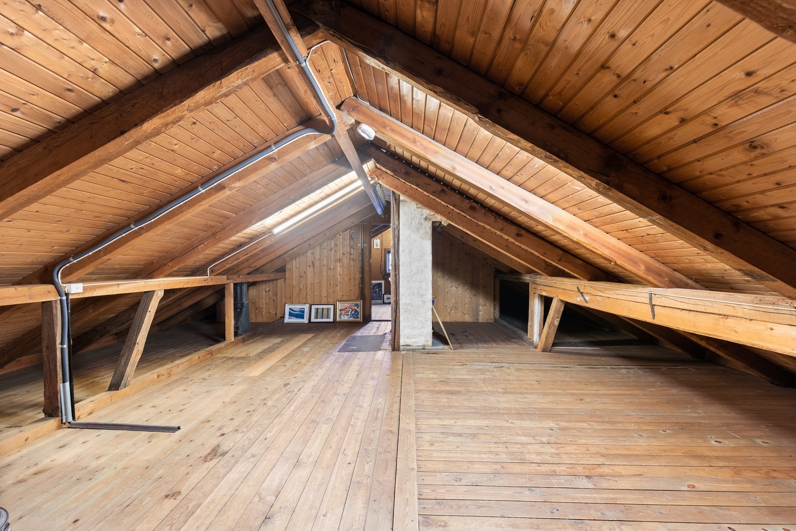 Det åpne loftsrommet har gulvbord og synlige takkonstruksjoner i tre. Galleribilde