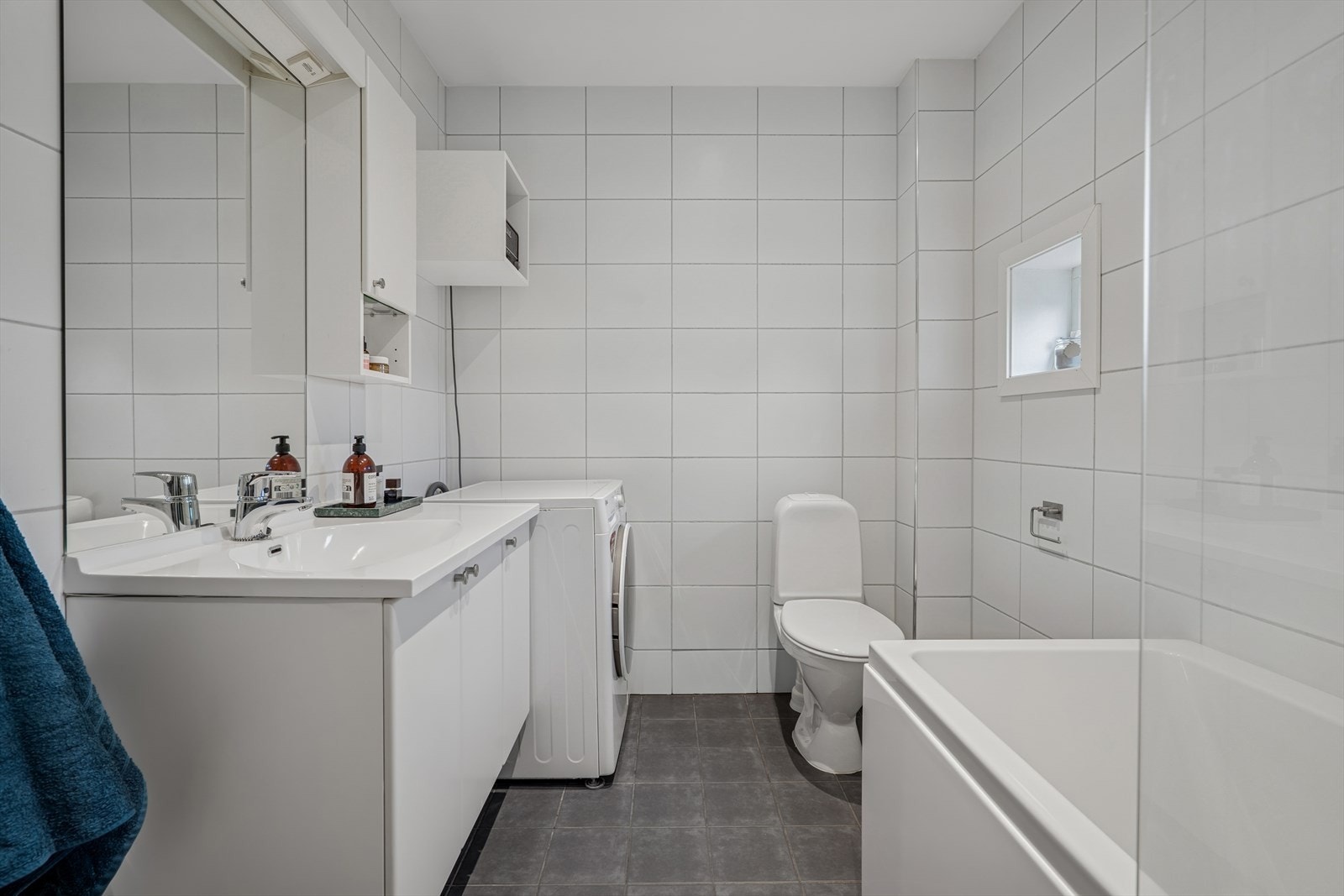 Flislagt bad med varmekabler i gulvet, opplegg til vaskemaskin og badekar Galleribilde