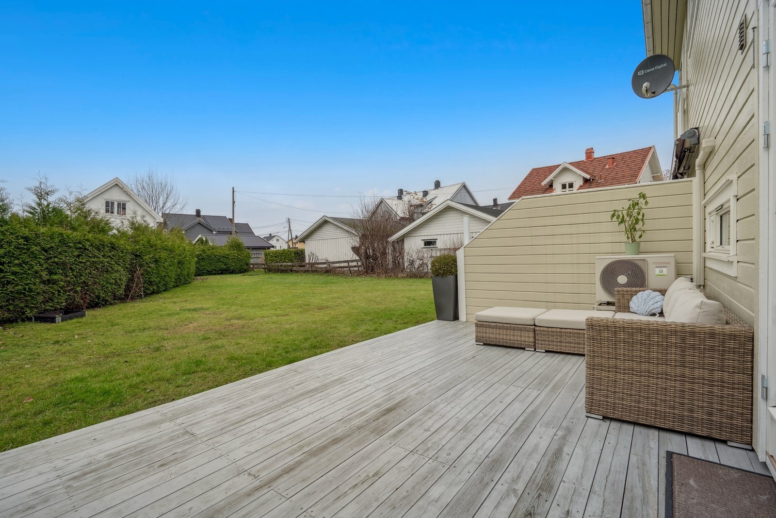 Solrik terrasse med en god plen foran seg. Plenen er felles for alle i rekken Galleribilde