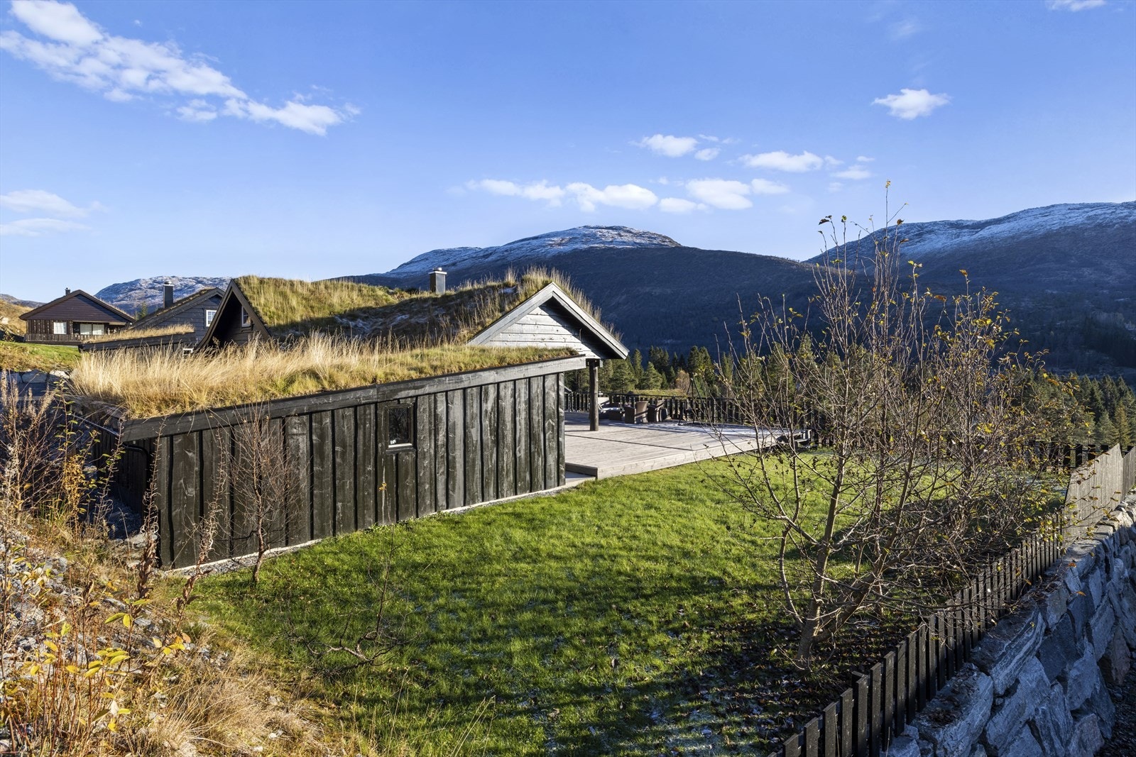 Deler av uteområde er opparbeidd med plenareal. Deler av bygg mot venstre er innreidd til sportsbod Galleribilde