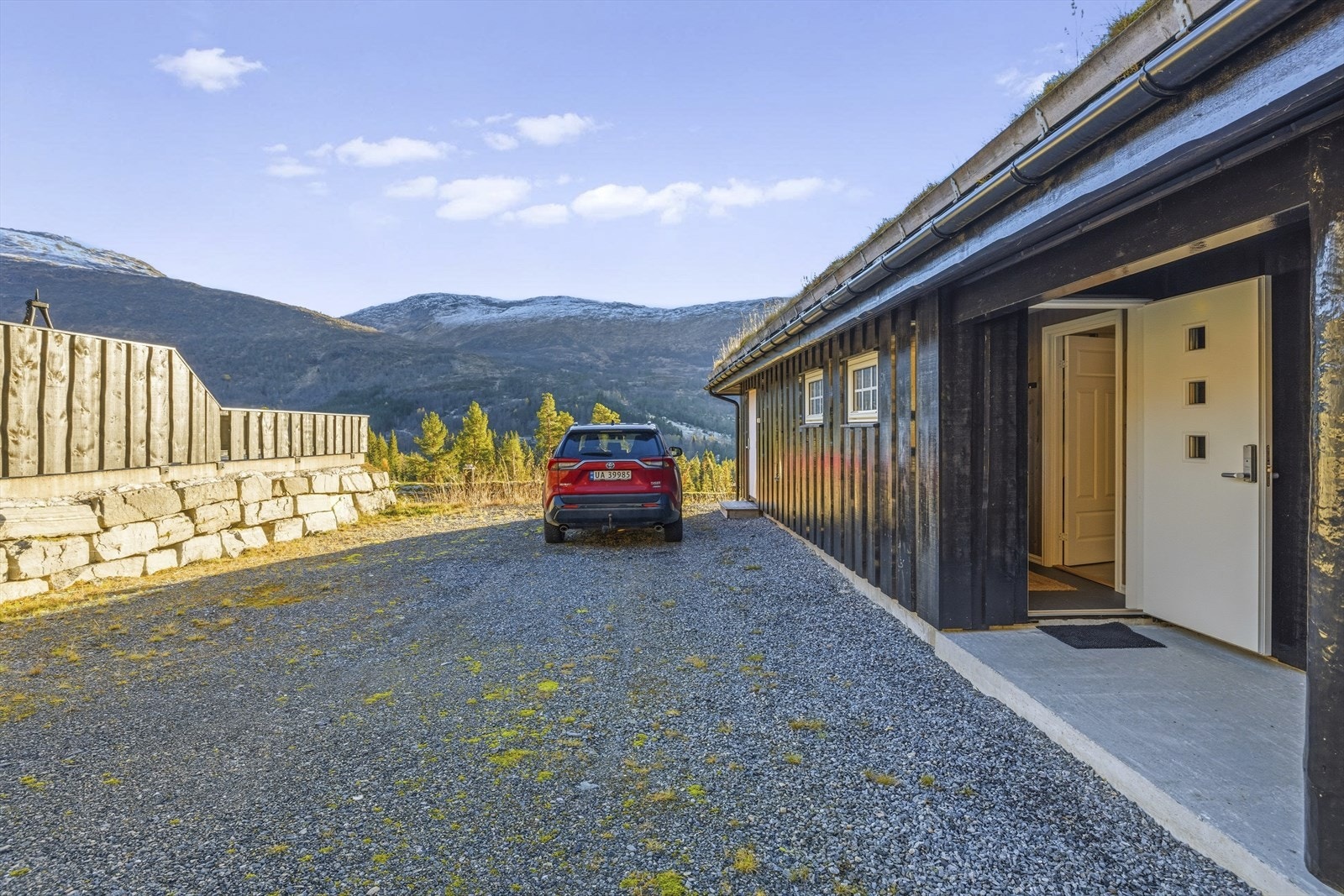 Stor og flat parkeringsareal mot inngangspartiet. Dør til sportsbod kan skimtast i bakgrunnen Galleribilde