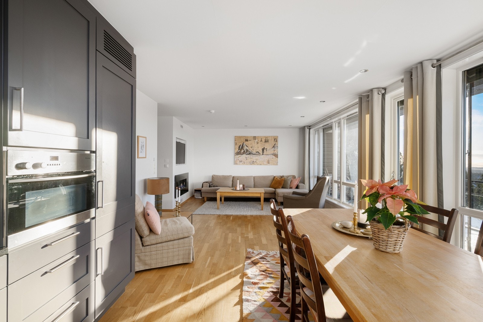 Stuen og kjøkkenet ligger i åpen løsning - et trivelig oppholdsrom med rikelig lys fra store vinduer. Galleribilde