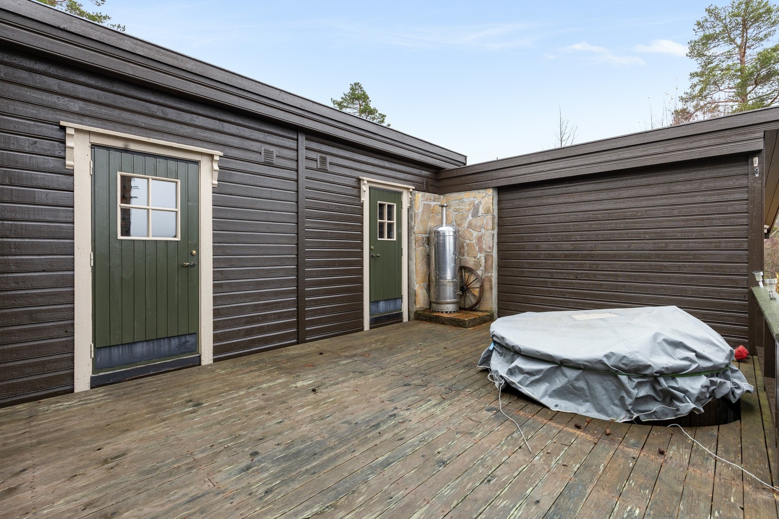 Dør til bod/teknisk(nærmest). Ellers ser vi døren til badstuen, samt den nedsenkede badestampen. Galleribilde