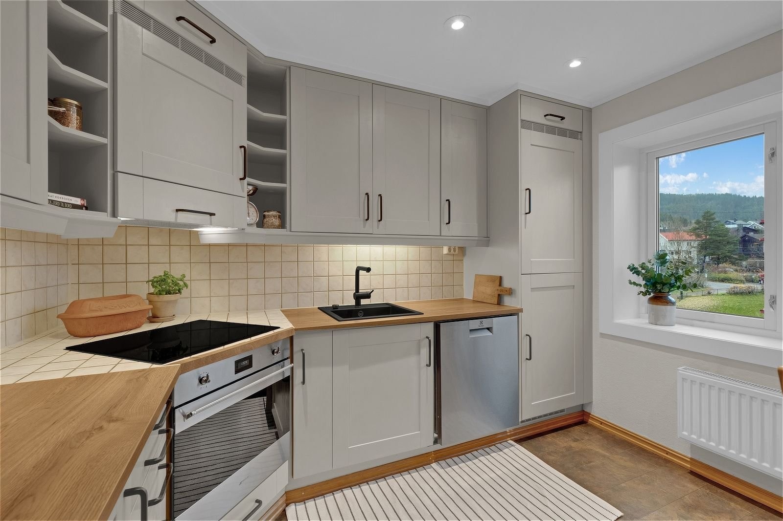 Separat kjøkken med profilerte fronter, benkeplater i laminat og nedfelt oppvaskkum i kompositt. Galleribilde