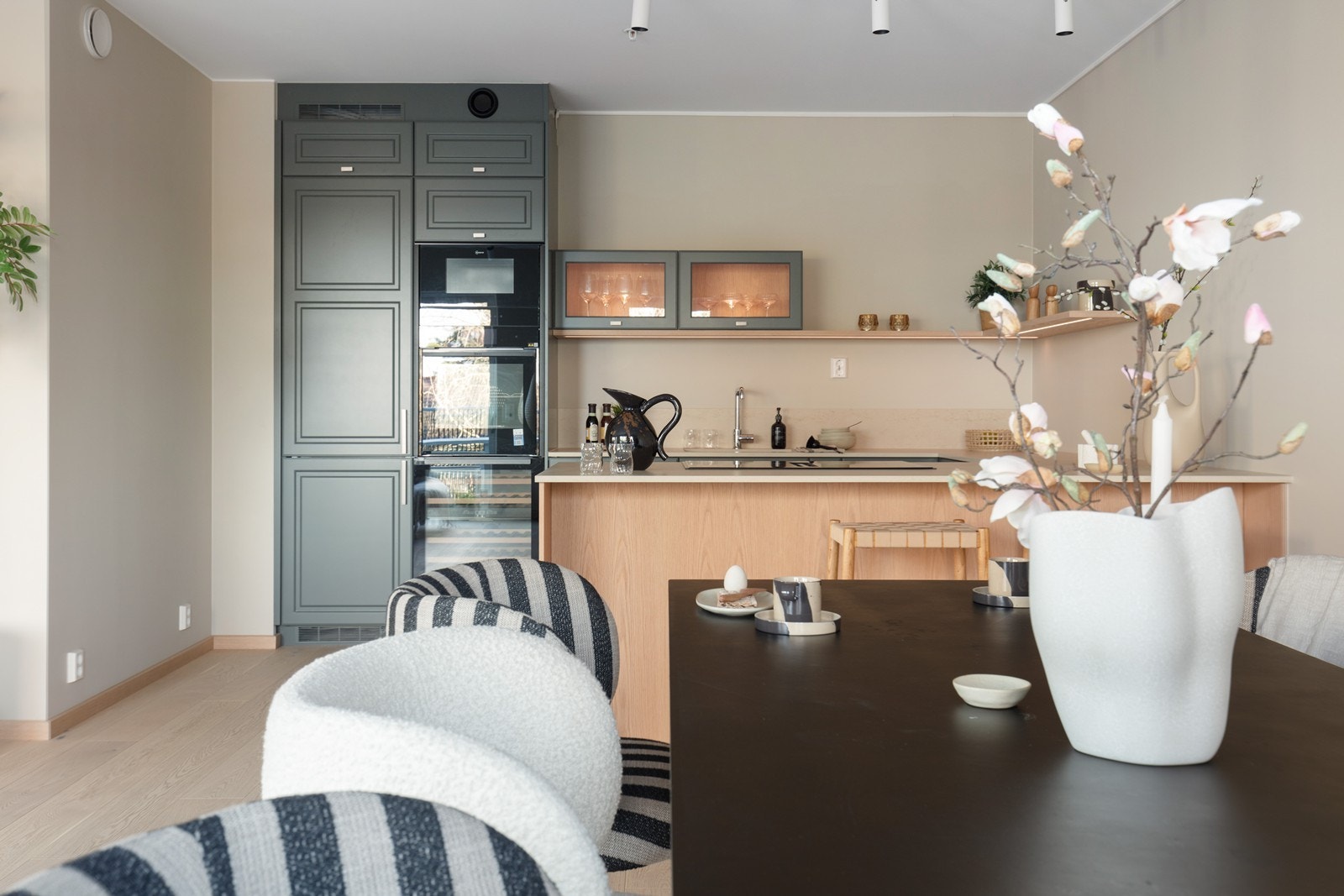 Kjøkkenøya fungerer som en naturlig romdeler mellom kjøkken og stue, og gir ekstra god benkeplass. Galleribilde