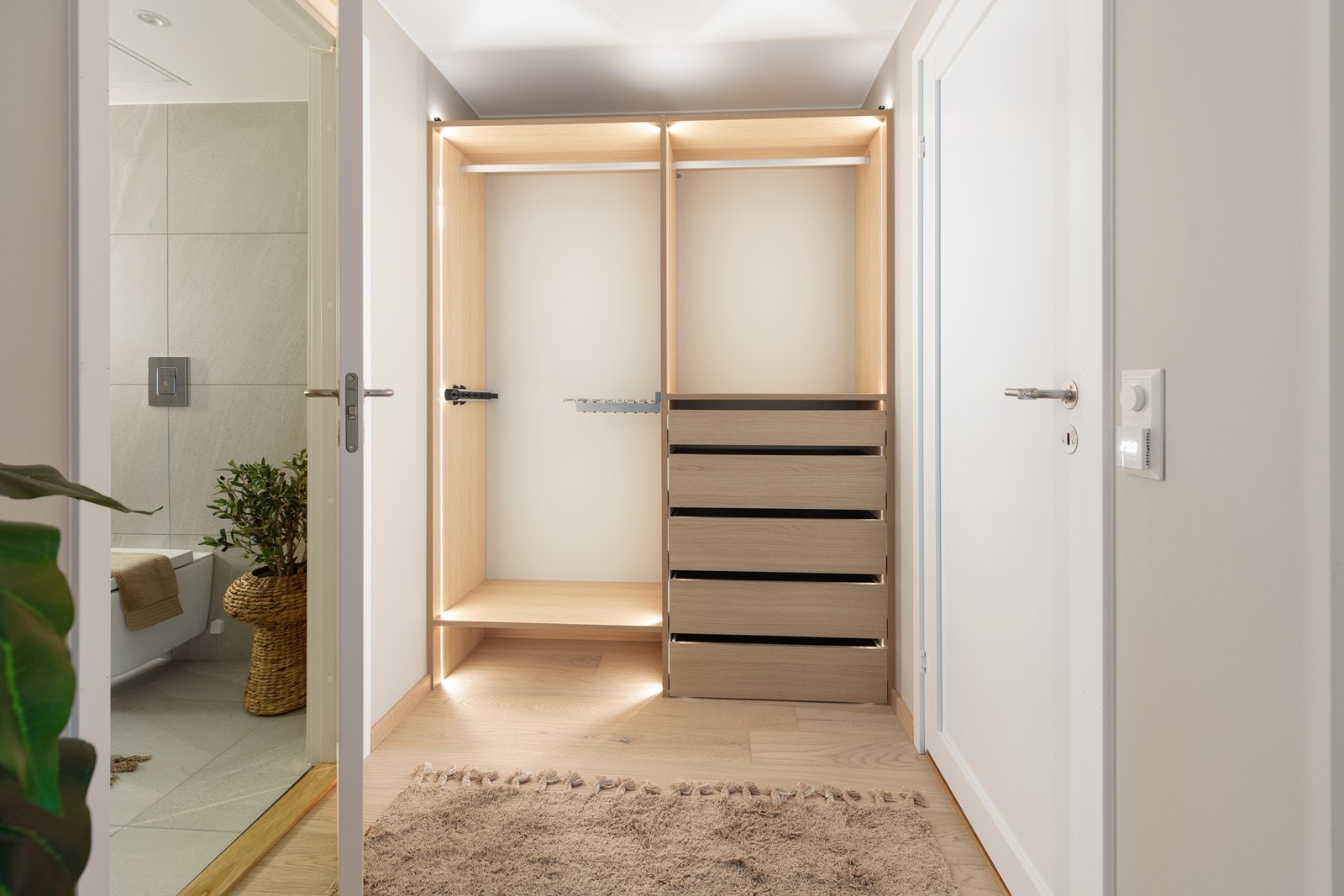 Praktisk omkledningsrom med åpen garderobeløsning og integrert belysning. Galleribilde