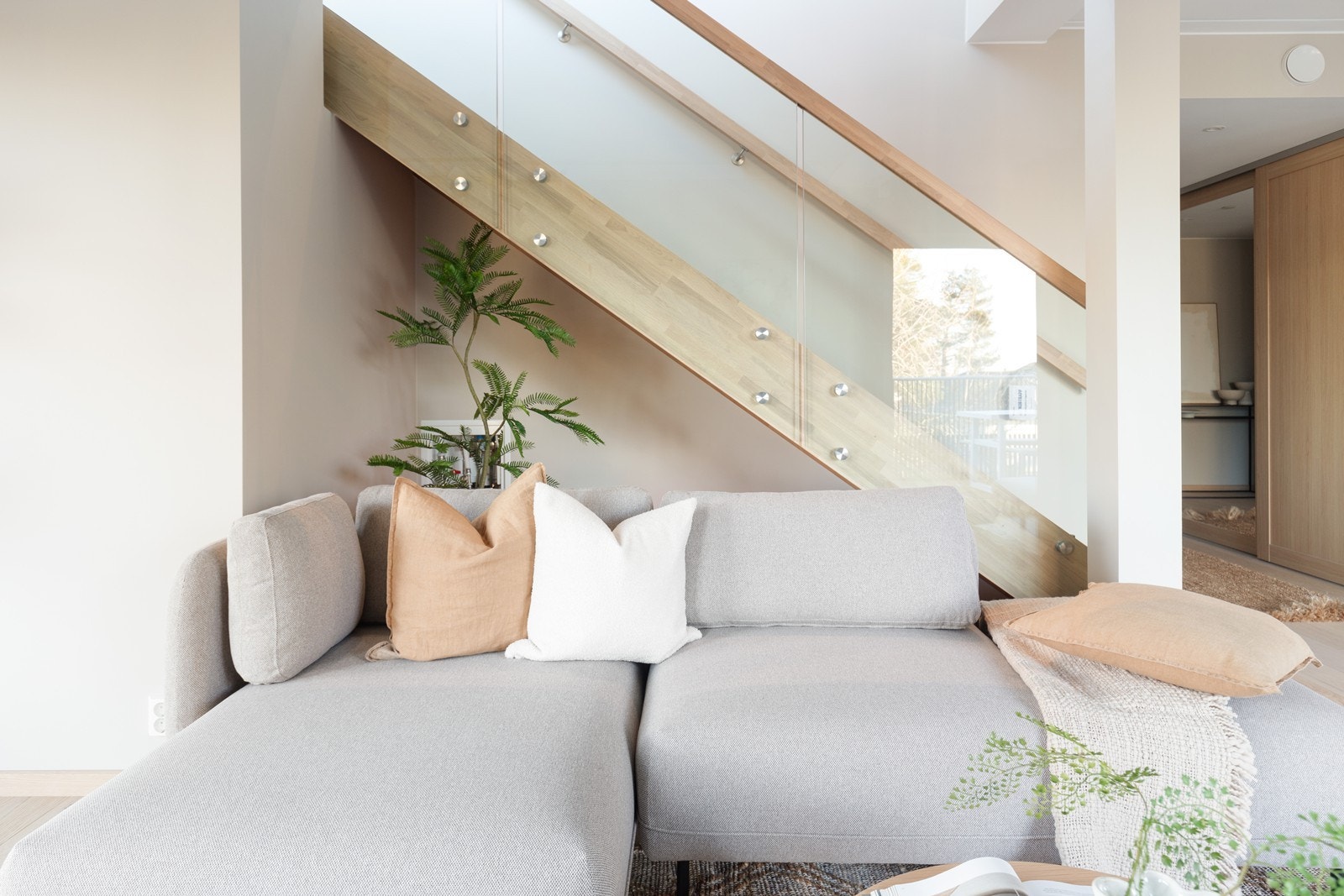 Trappen i eik med glassrekkverk leder opp til leilighetens øverste etasje. Galleribilde