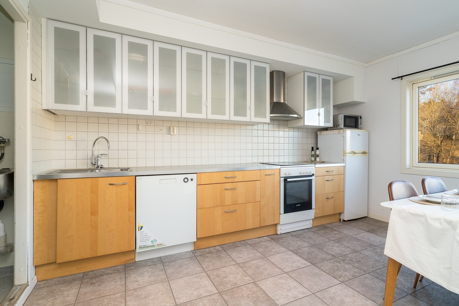 Det er heltre fronter på underskapene, mens overskapene har et moderne uttrykk med fronter i frostet glass. Mellom over- og underskap er det fliser som beskytter mot vannsprut og stekefett ved matlaging. Galleribilde