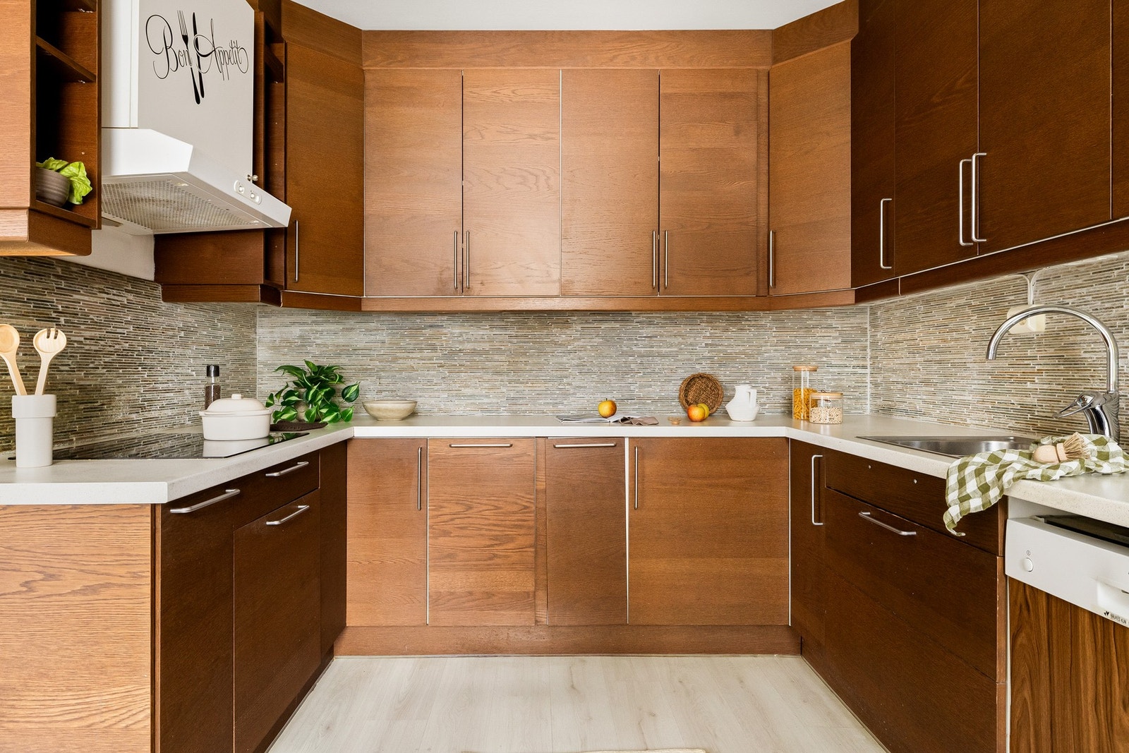 Kjøkkeninnredning med finèrte fronter og benkeplate i laminat. Galleribilde