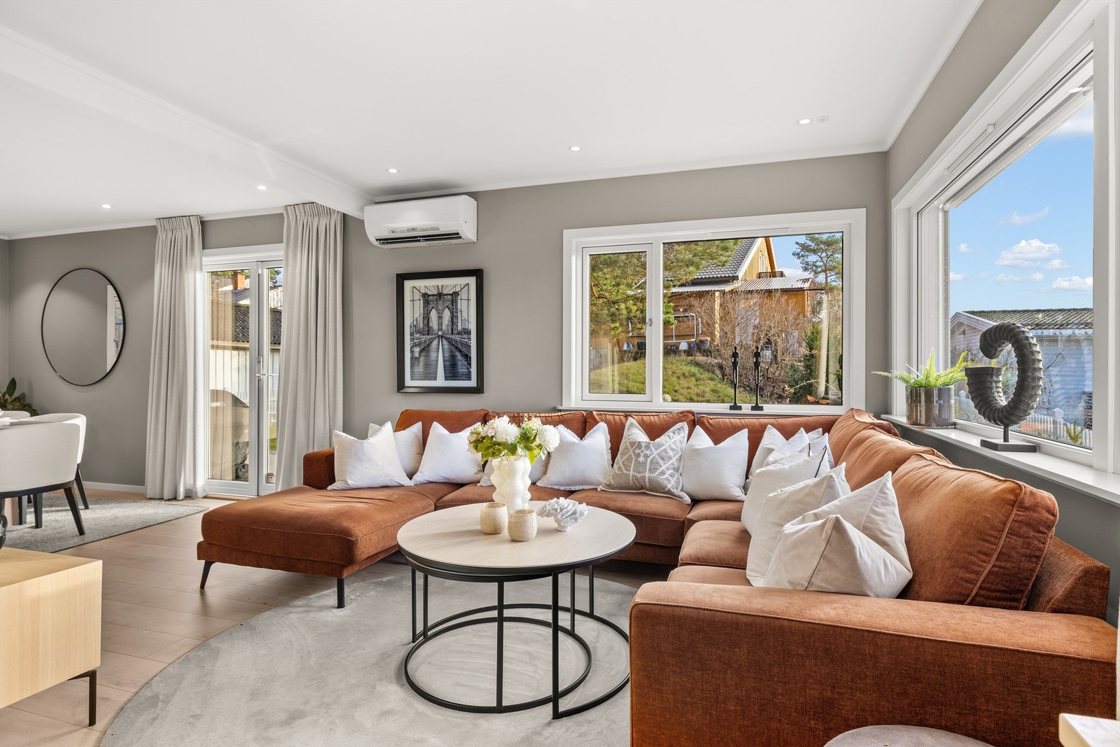 Kombinert stue og spisestue i vinkelløsning med vinduer mot øst, syd og vest som gir mye naturlig lys Galleribilde