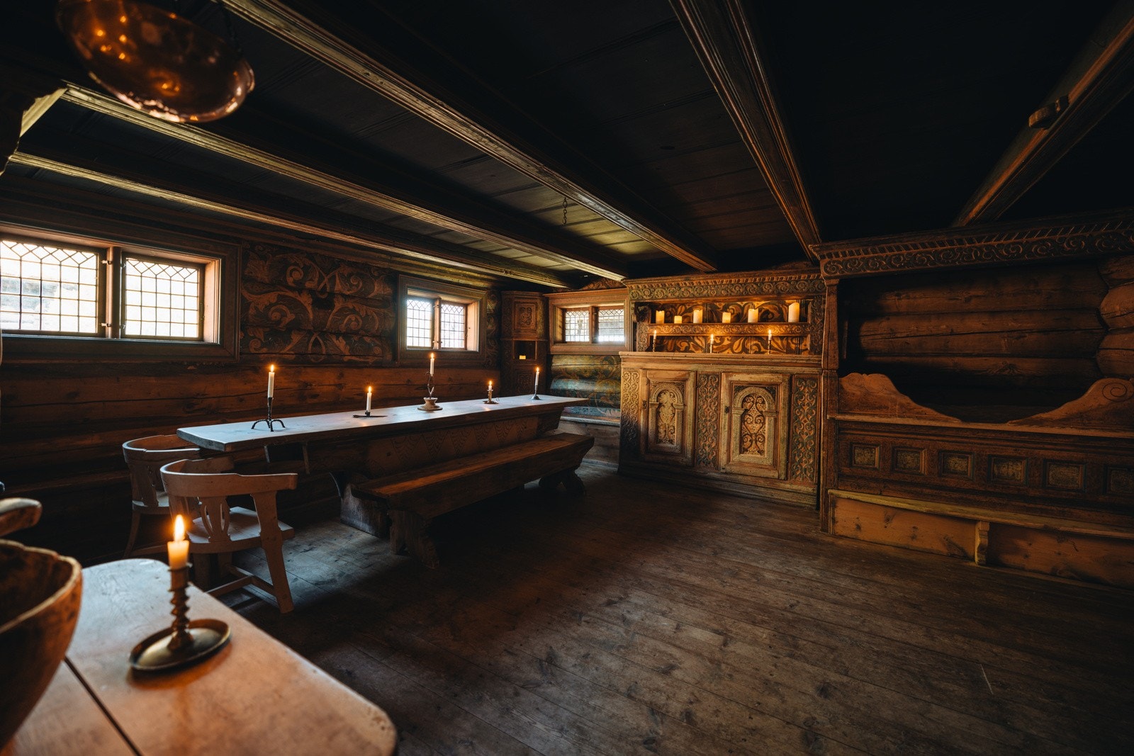 Gulvene består av tregulv, veggene er rosemalte tømmervegger og i himlingen er det panel med bjelker Galleribilde