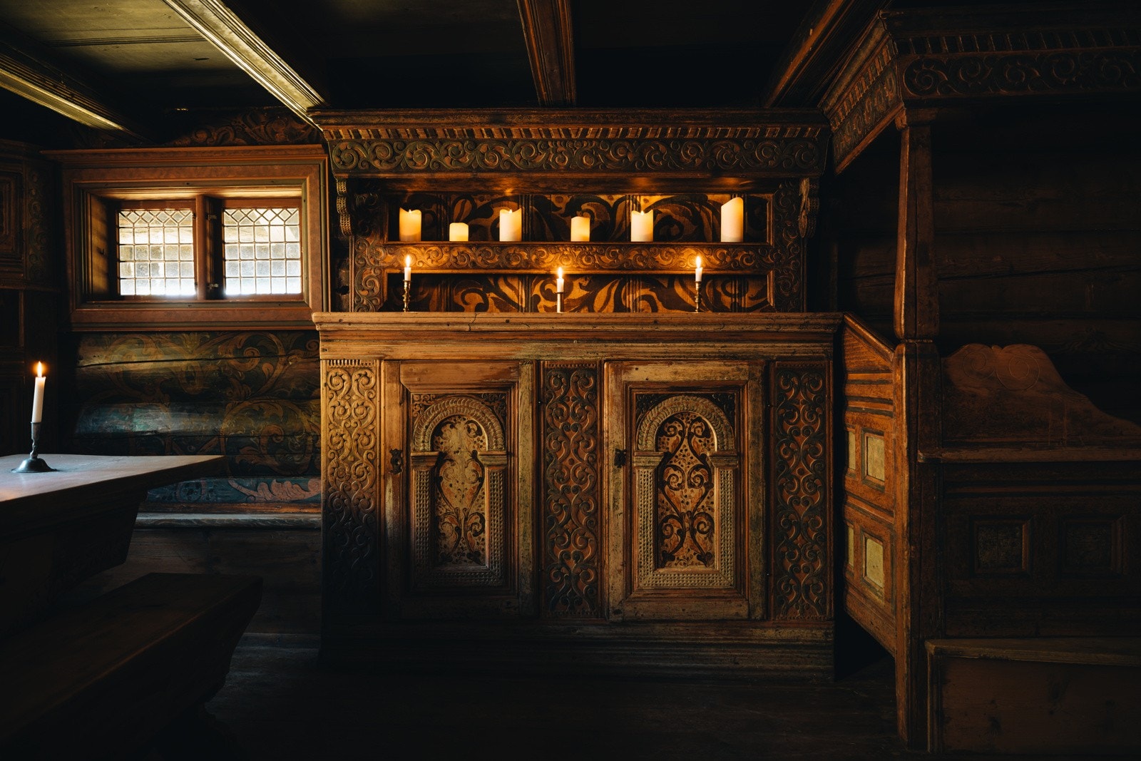 Fastmonterte kronesenger, kroskap og framskap er rosemalte og har utskjæringer Galleribilde