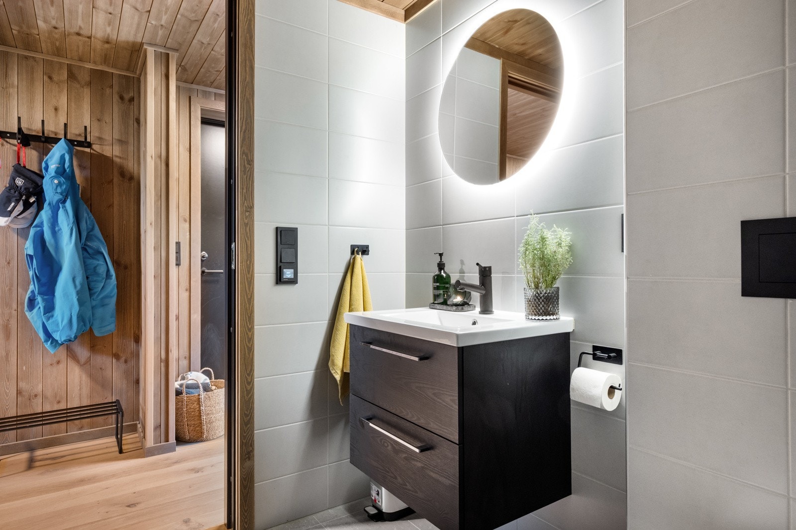 Lekkert helfliset bad med vegghengt toalett, dusjhjørne med innskyvbare dusjvegger og servant med underskap. Galleribilde