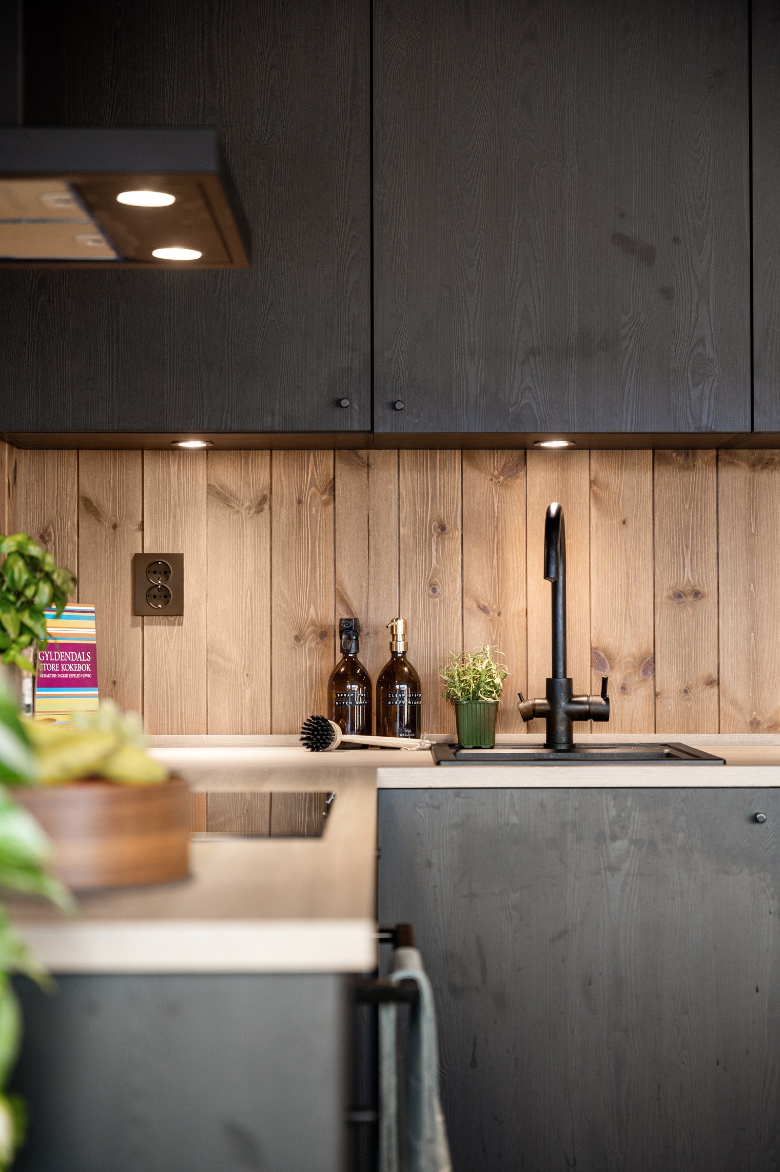 Elegant kjøkkeninnredning med over- og underskap, slette fronter og benkeplate av laminat. Det er integrerte hvitevarer med oppvaskmaskin, koketopp med stekeovn, samt kjøleskap med frys. Røros avtrekksvifte. Galleribilde