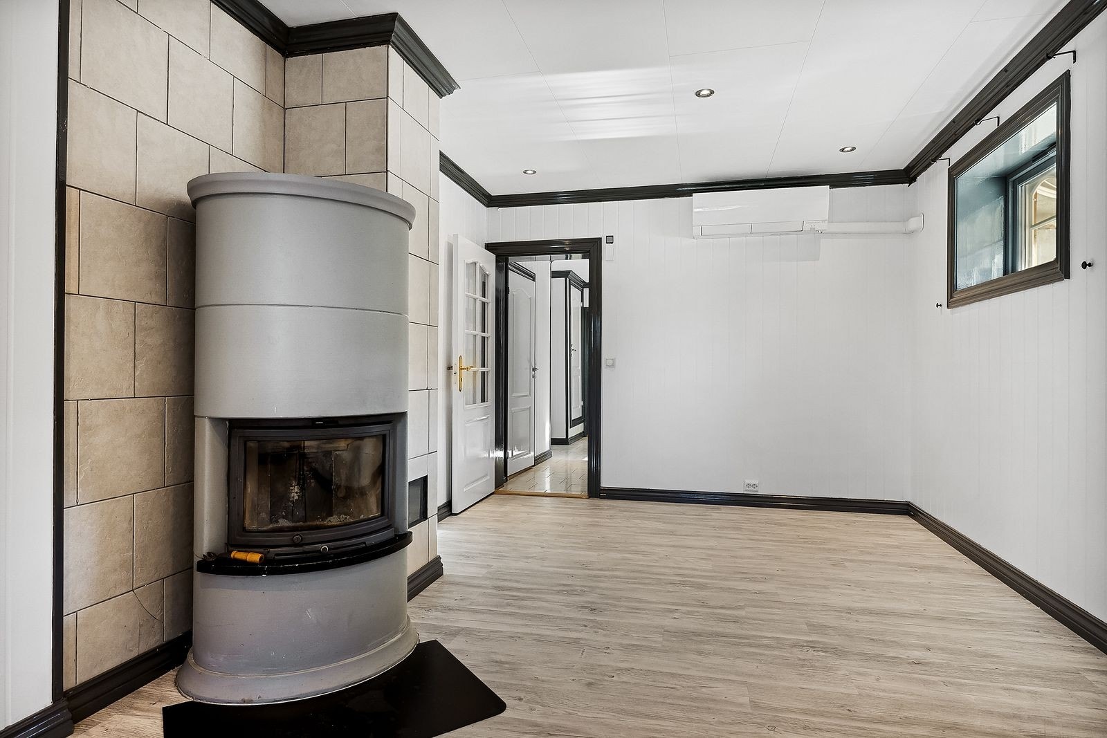 Stuen har en solid vedovn og god plass til både spisebord og sittegruppe Galleribilde