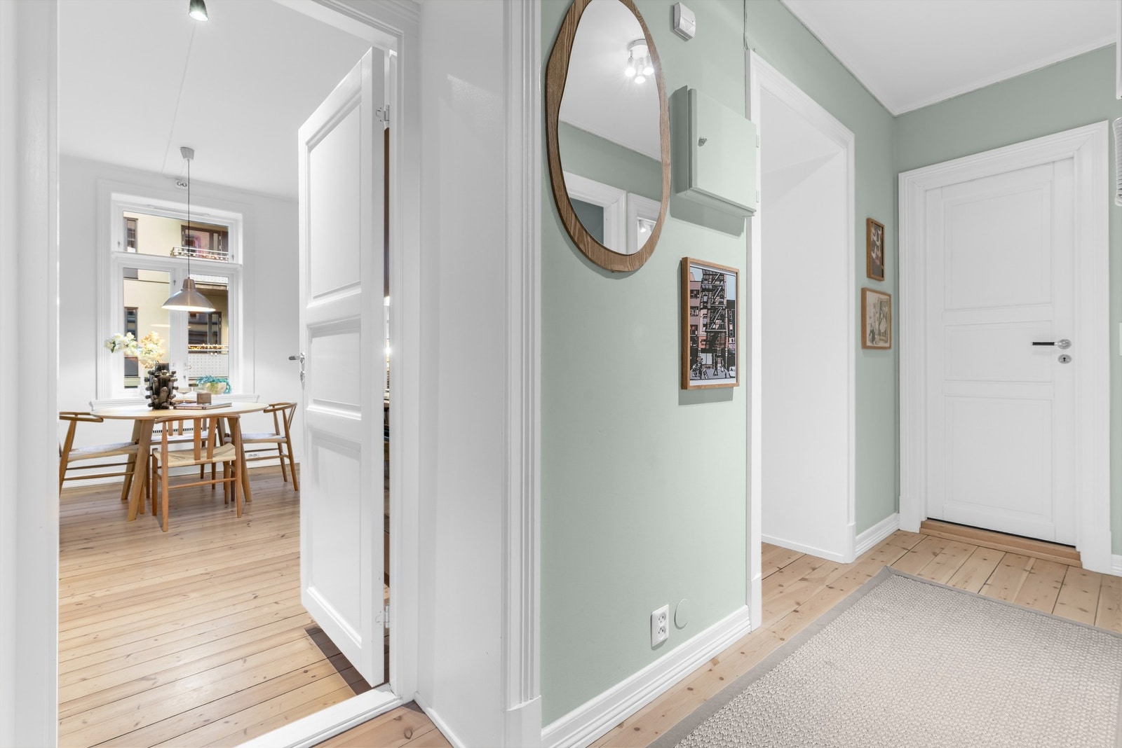 Entréen har glatte, malte flater i en delikat lys grønnfarge, og på gulvene er det heltre furugulv som ble slipt og lakkert i 2020 Galleribilde