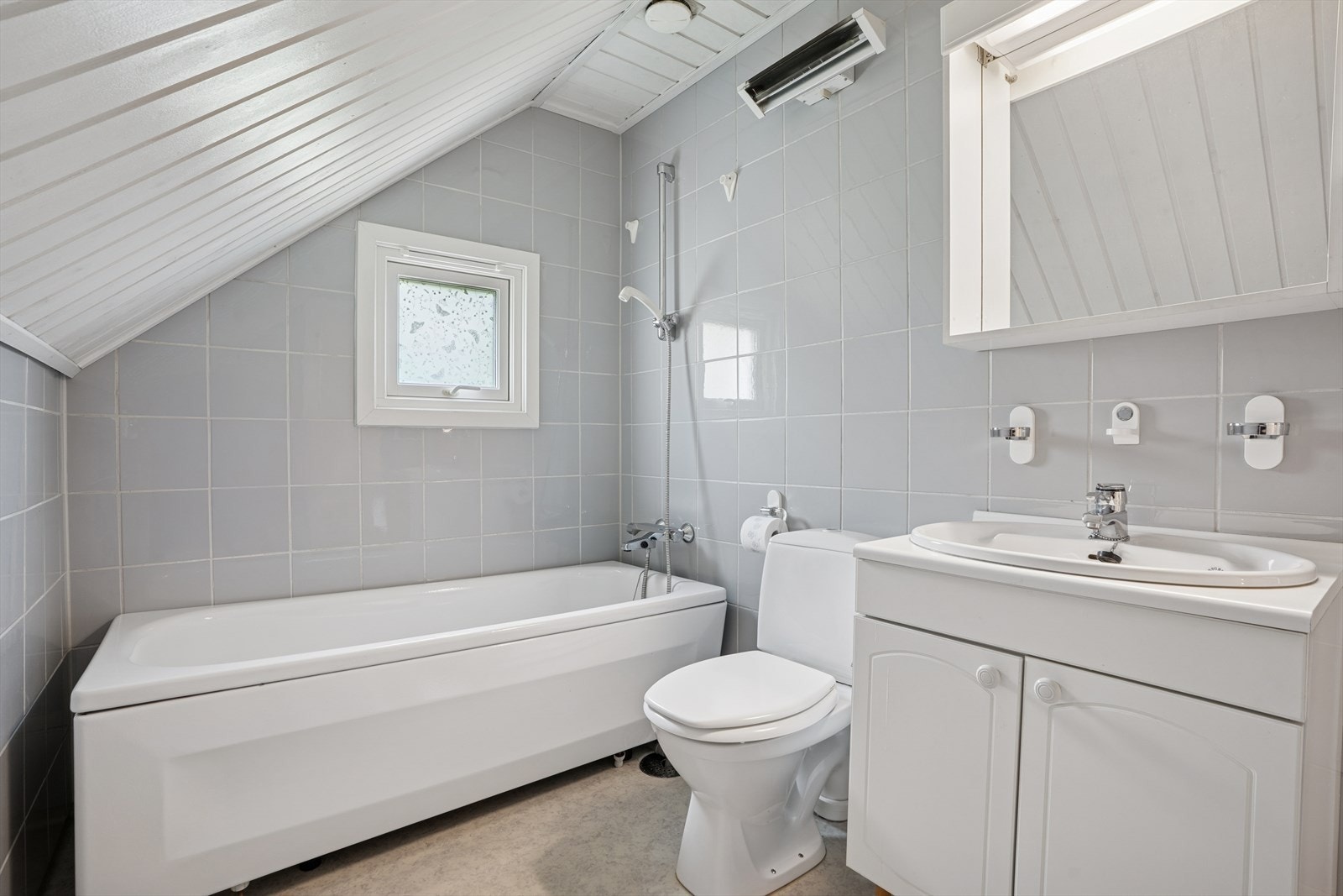 Bad i 2. etasje er fra byggeåret og er innredet med nedfelt servant, toalett og badekar. Speil på vegg over servant. Galleribilde