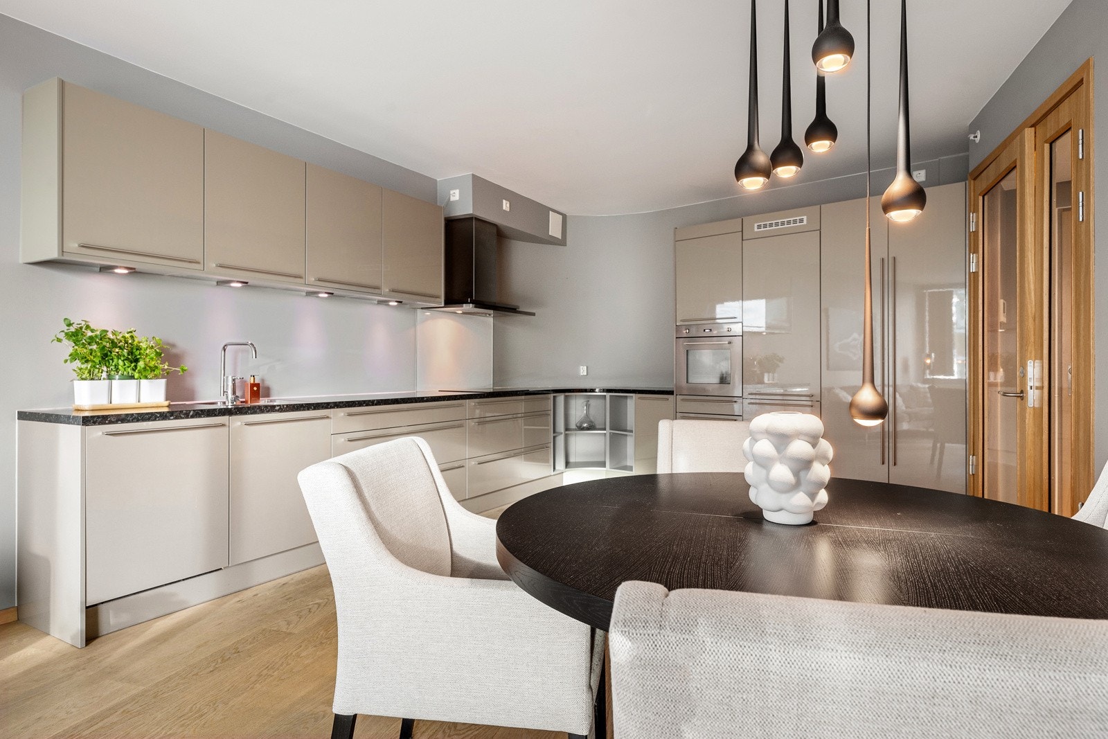 Delikat kjøkkeninnredning fra Crown Imperial med integrerte hvitevarer fra Smeg. Kombi kjøl- og fryseskap, oppvaskmaskin, stekeovn, induksjonstopp og ventilator med avtrekk. Galleribilde