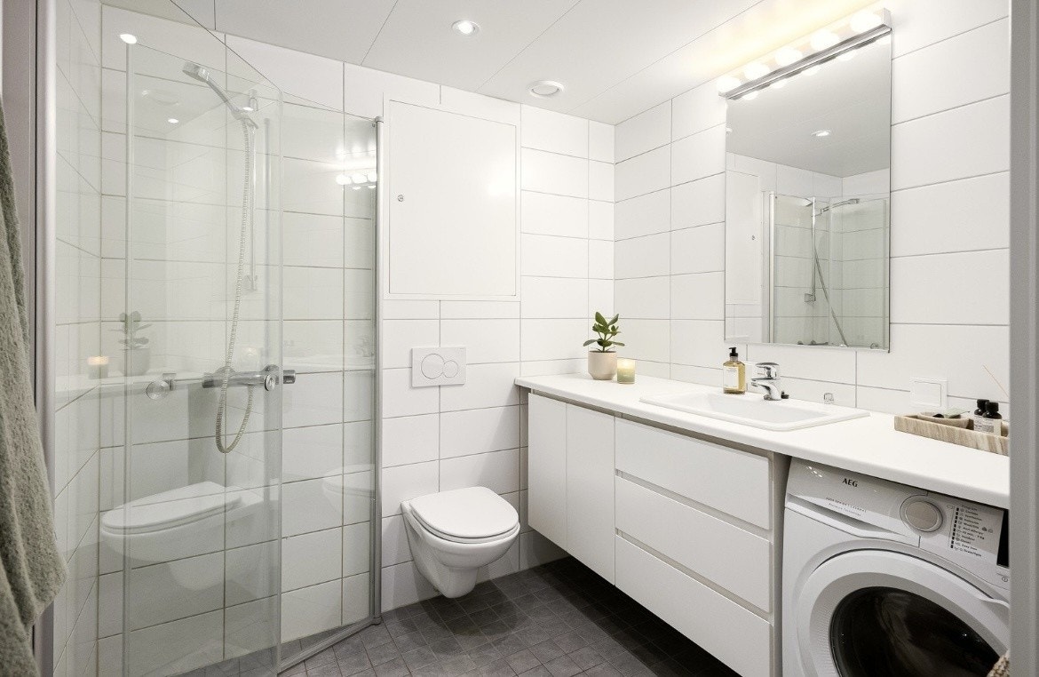 Flislagt bad med glassdører til dusj. Galleribilde