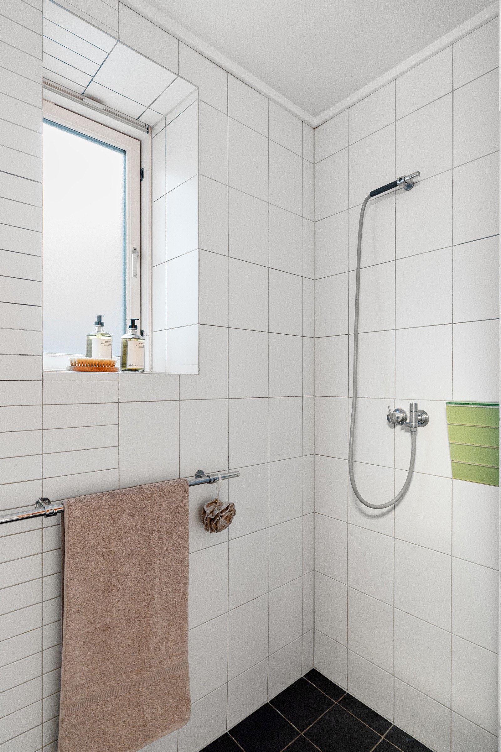 Svingbar dusjdør i glass og to stk integrerte ett-greps armaturer fra Vola med hånddusjer i krom Galleribilde