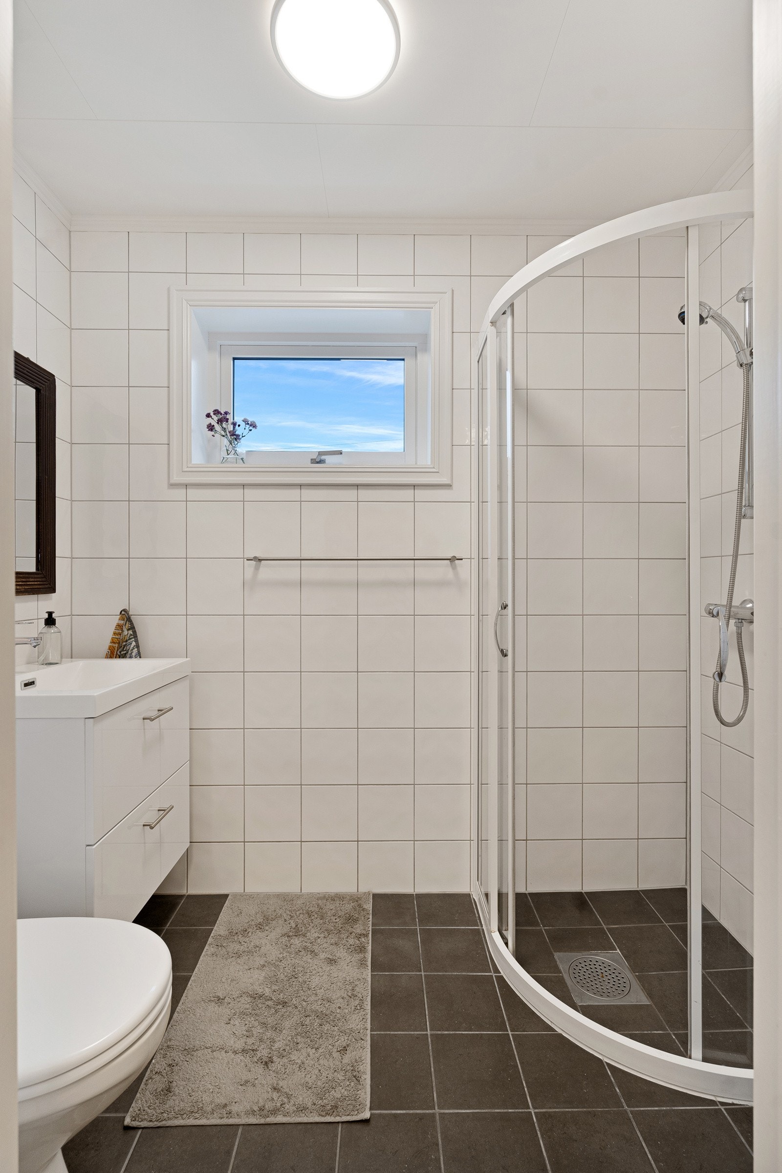 Badet i 1. etasje er flislagt på gulv og vegger med tidløse fliser Galleribilde