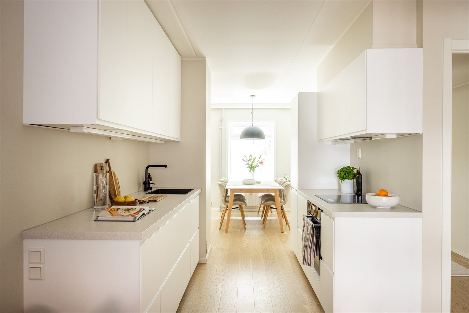 Stilrent kjøkken (2022) i åpen løsning mot stue og spisestue - noe som skaper en sosial atmosfære. Galleribilde