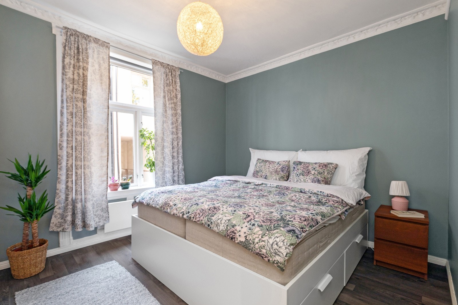 Romslig soverom med stukkatur og vegger malt i en nydelig grønnfarge. Galleribilde