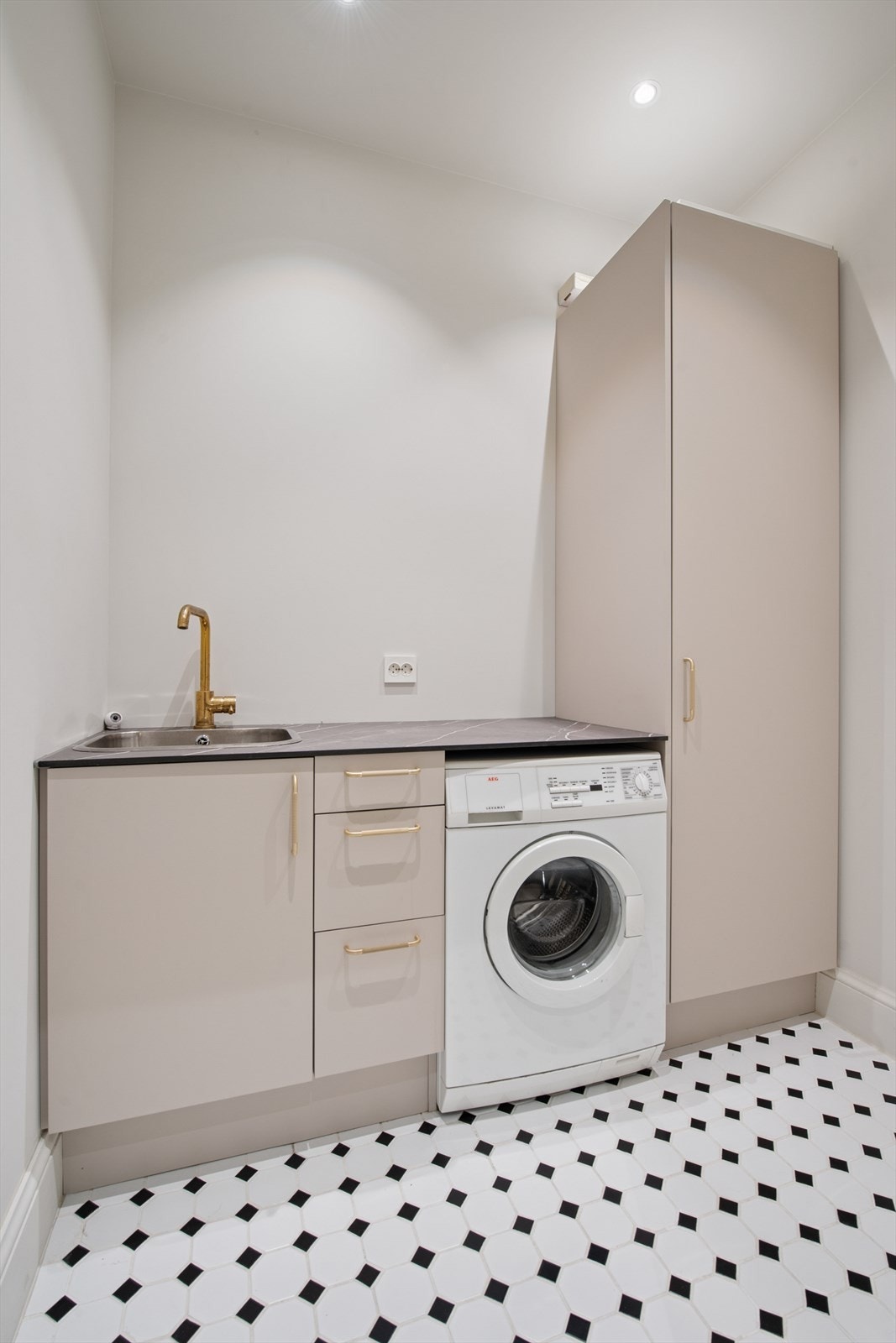 Innenfor badet finner du et eget vaskerom, som er både funksjonelt og stilfullt. Galleribilde