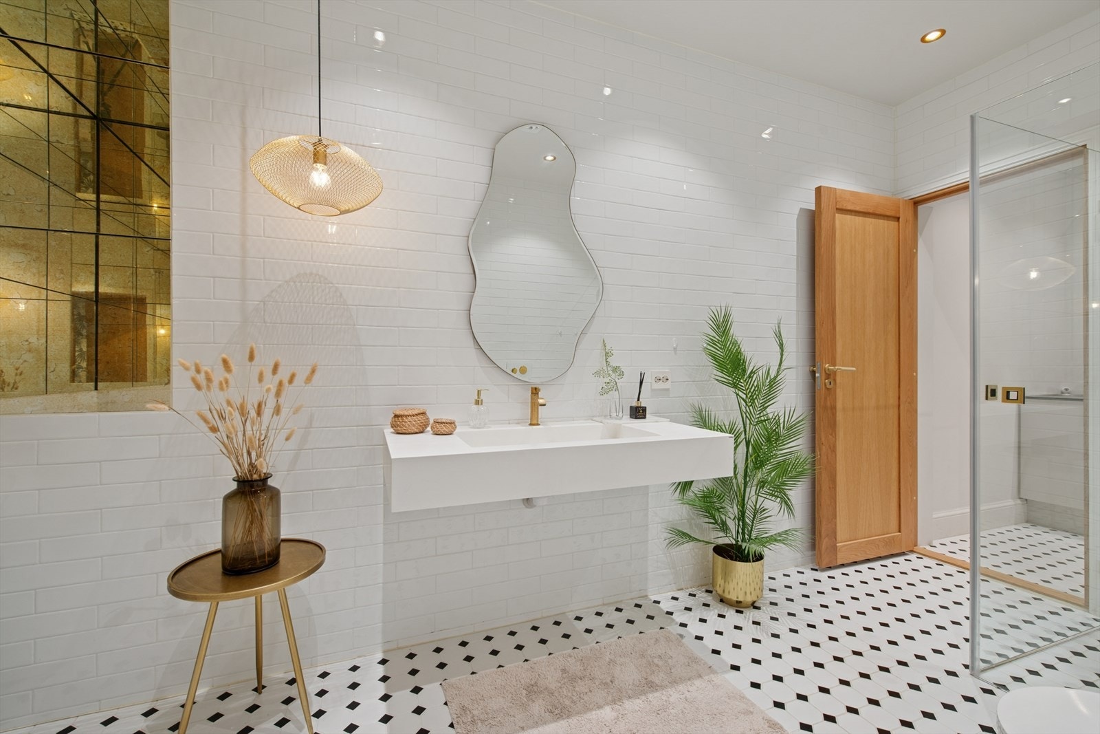 Badet er utstyrt med vegghengt toalett, et innbydende badekar, dusjhjørne og servant med overhengende speil. Galleribilde