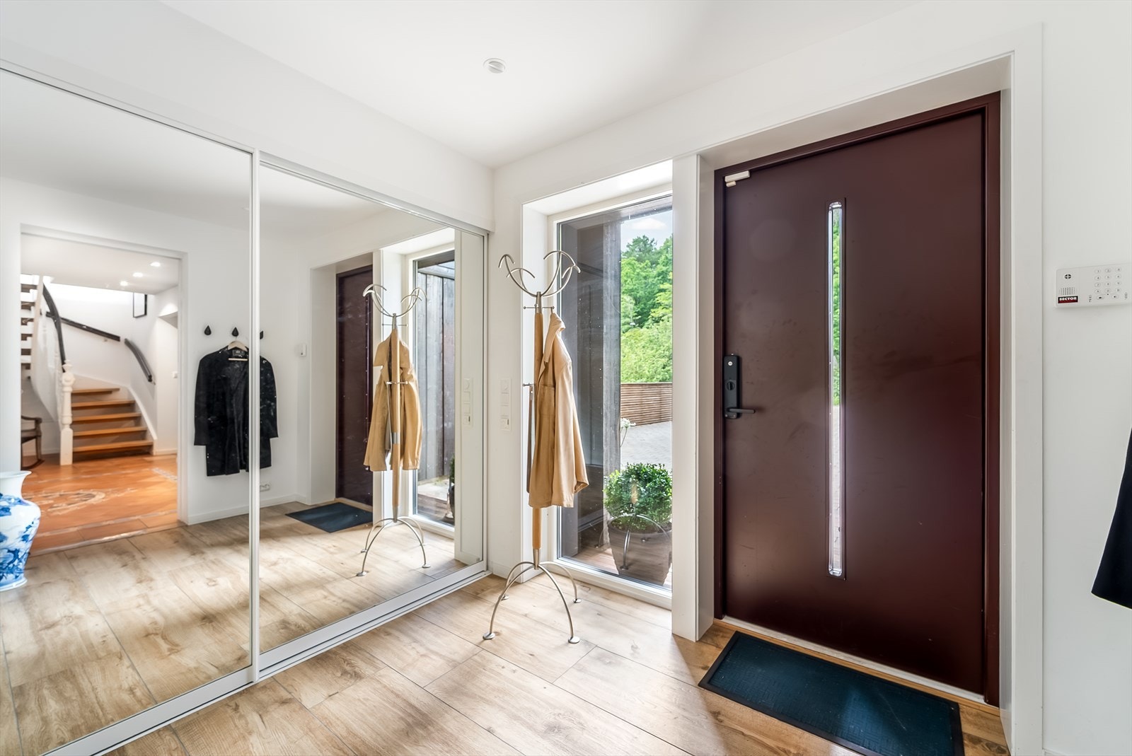 Inngangspartiet fører inn til en romslig hall med avkledningsplass. Garderobeskap med speilskyvedører gir en god romfølelse og det store vinduet bringer godt med lys inn i rommet. Galleribilde