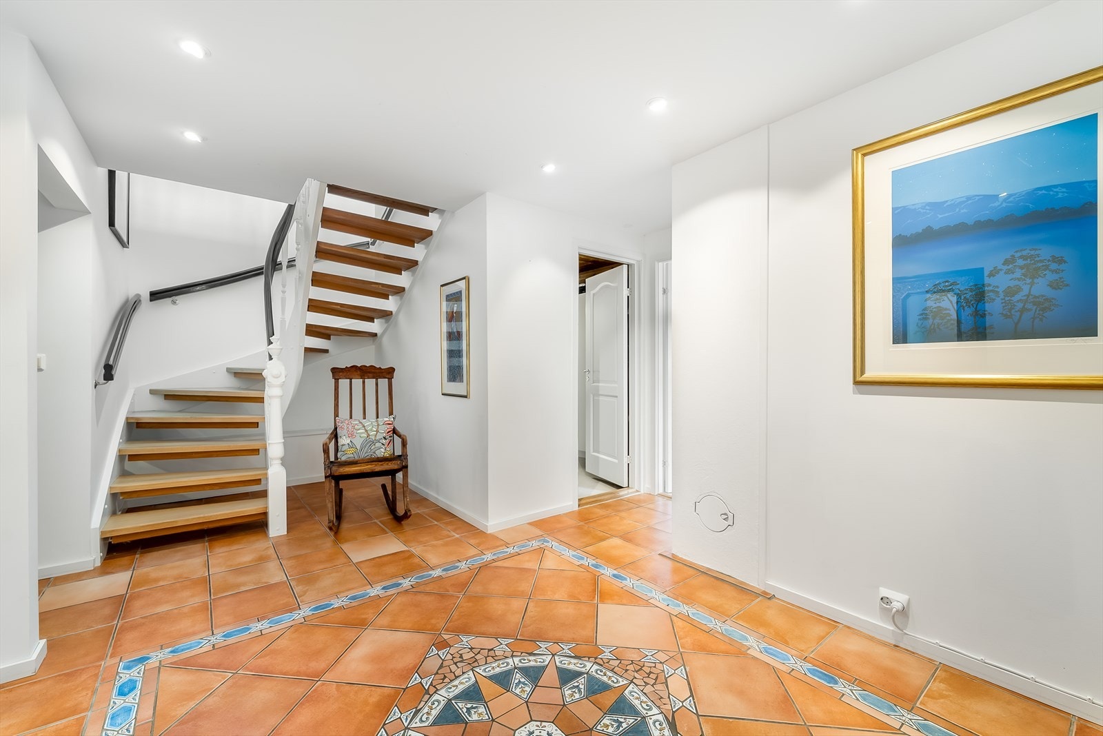 Luftig hall med trapp opp til boligens 1. etasje. Galleribilde