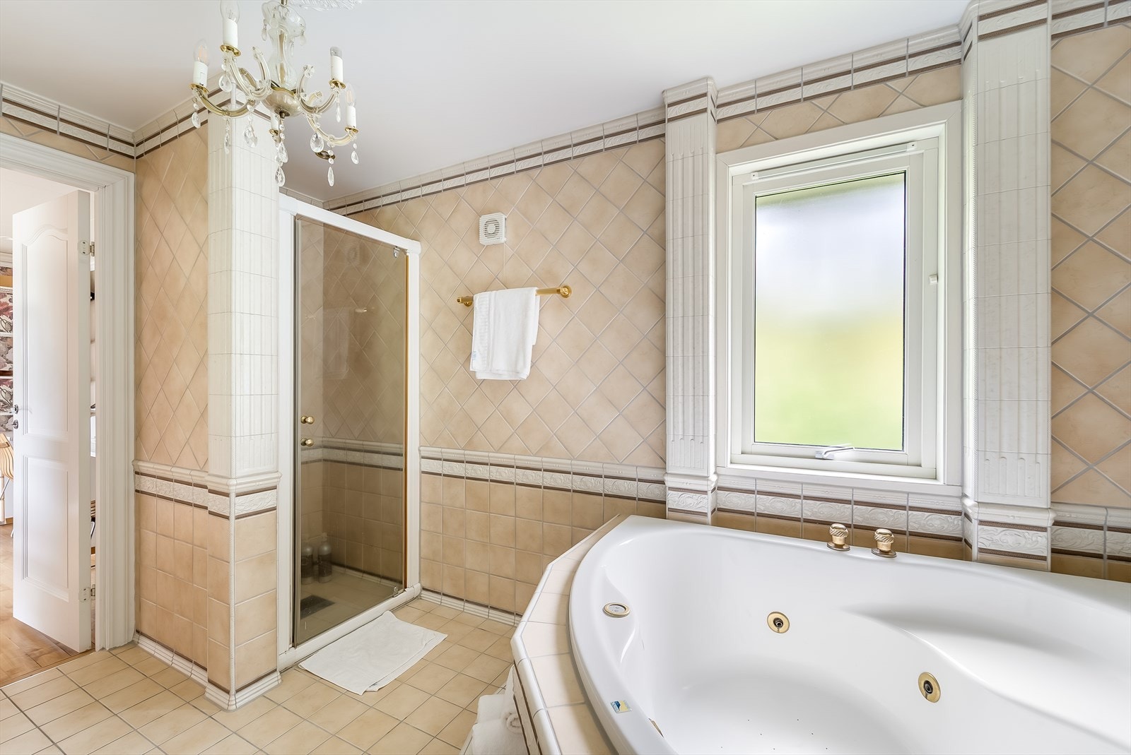 Badet er utformet med baderomsinnredning, toalett, boblebad og dusjløsning med glassvegg. Galleribilde